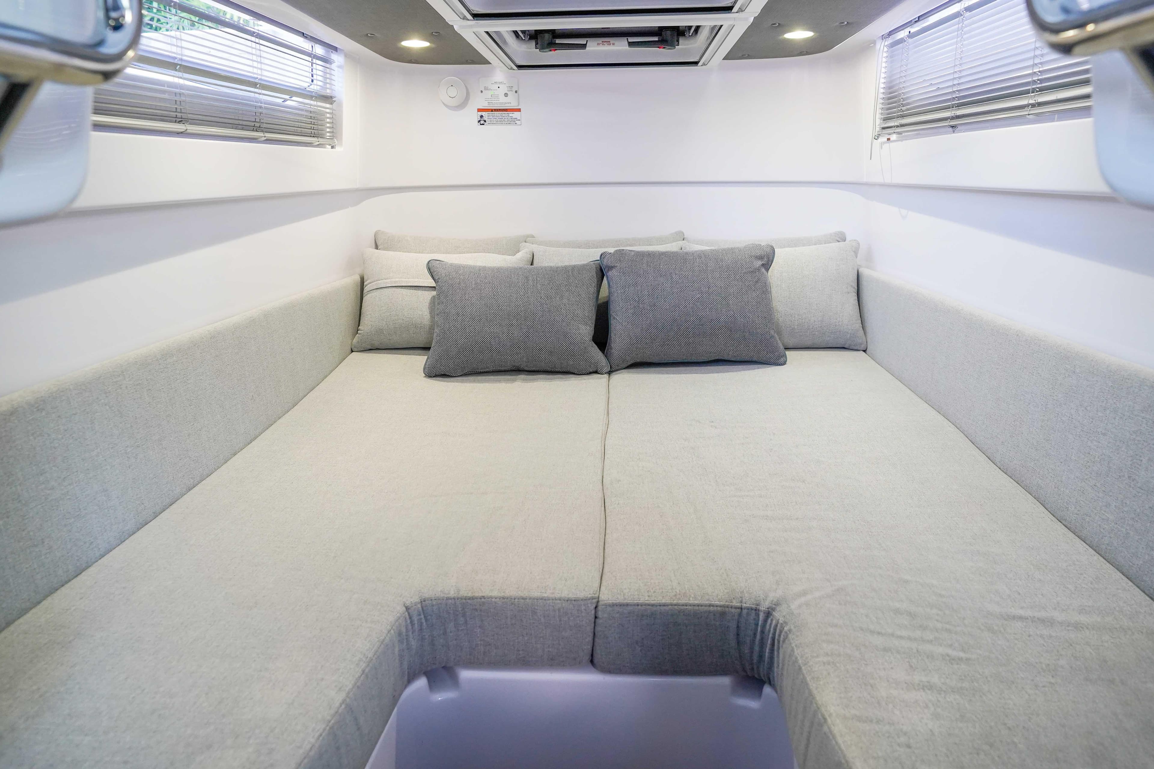 2024 Axopar 37 XC Cross Cabin interior with cozy gray bedding and cushions.