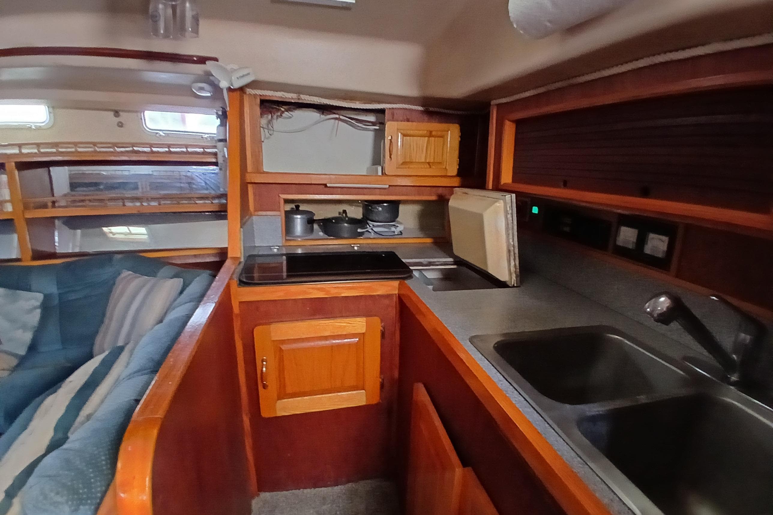 Interior of 1982 Morgan 416 yacht featuring a compact kitchen with wooden cabinetry.