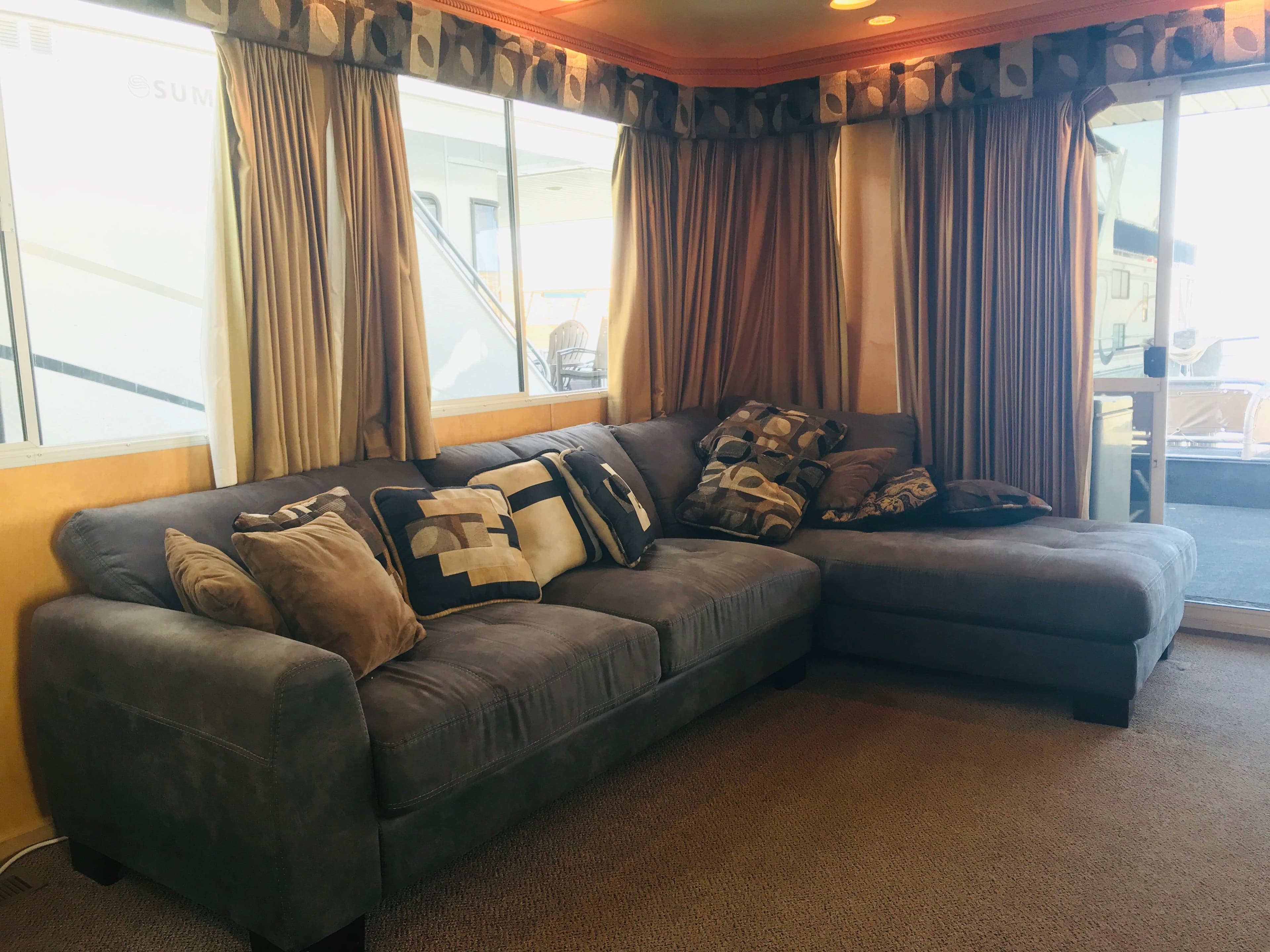 Luxurious 2005 Stardust Cruisers houseboat interior with cozy sectional sofa and decorative pillows.