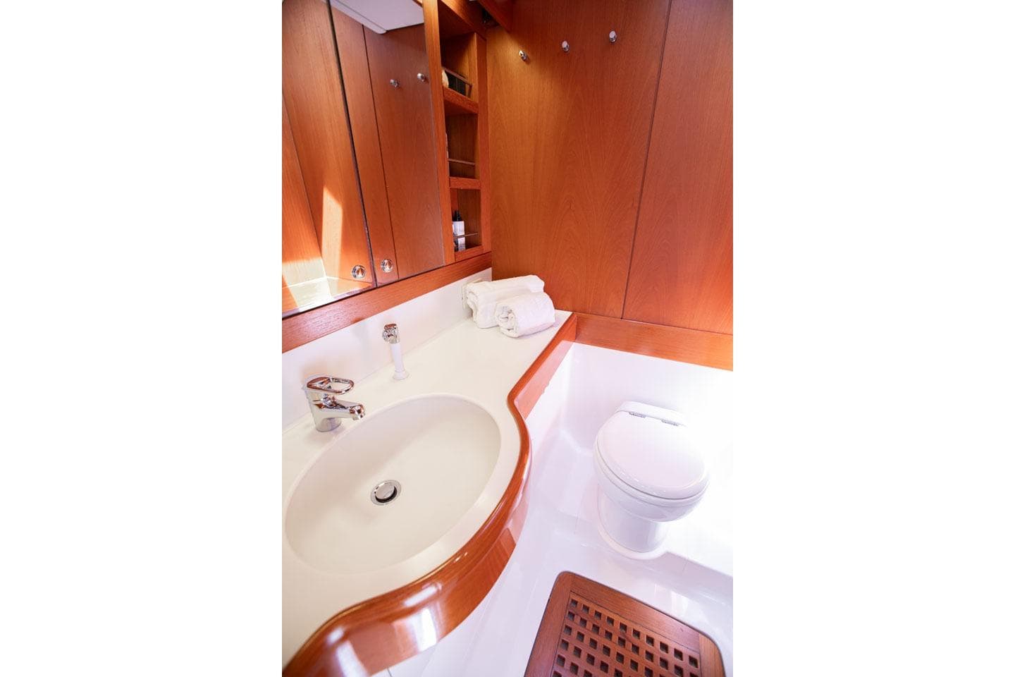 Luxurious bathroom in 2001 Nautor Swan 80 yacht, featuring elegant wood cabinetry and modern fixtures.