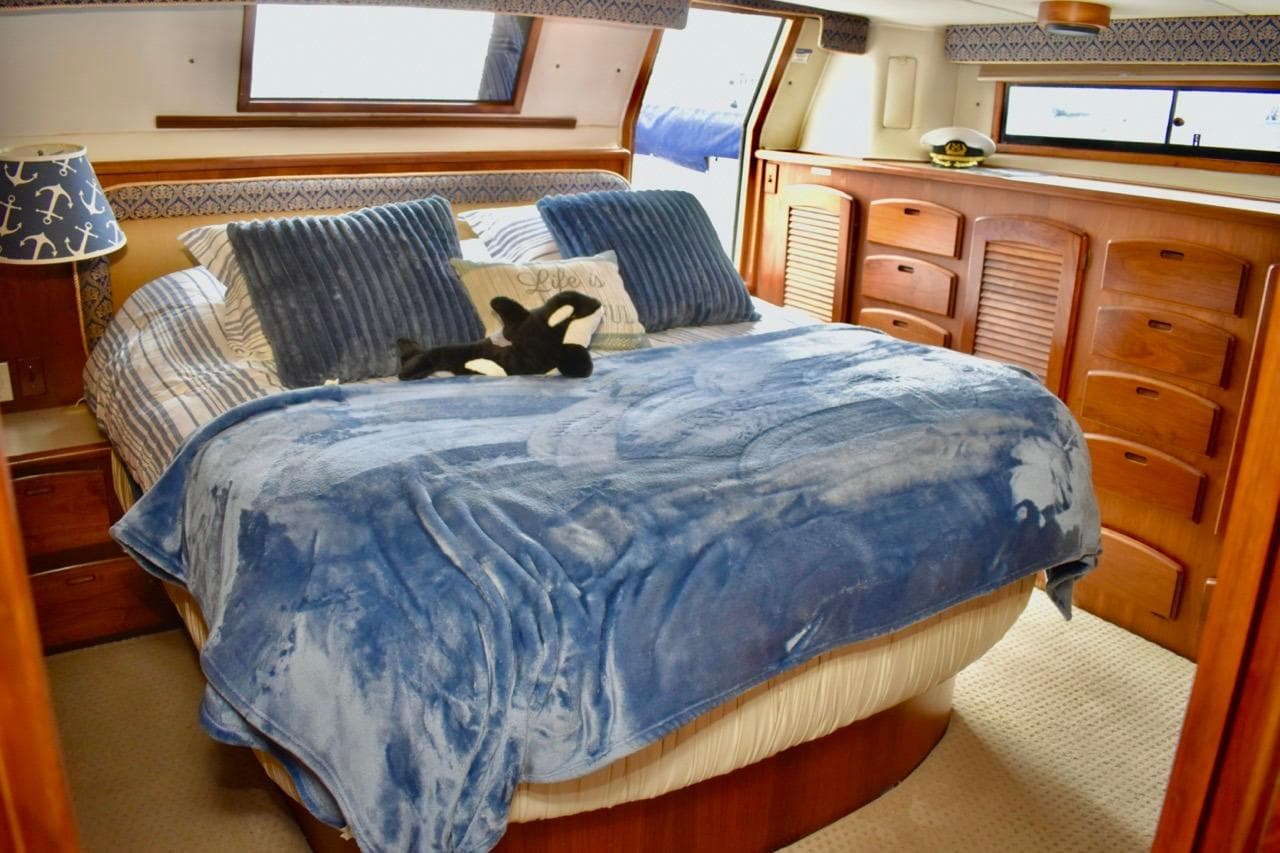 Luxurious bedroom interior of 1987 Californian 55 Cockpit Motor Yacht with blue bedding.