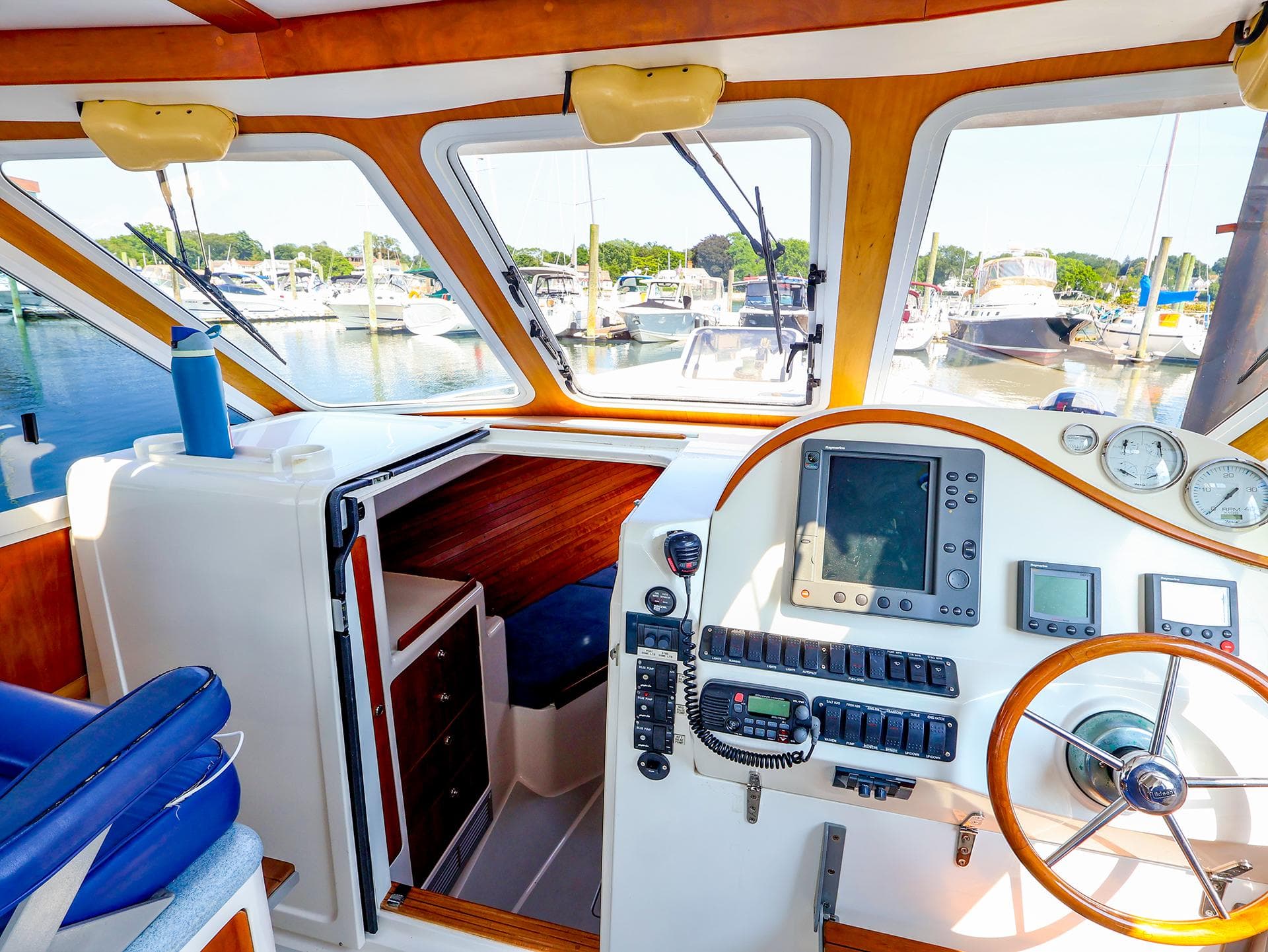 Interior of 2004 True North 38 boat with navigation equipment and marina view.