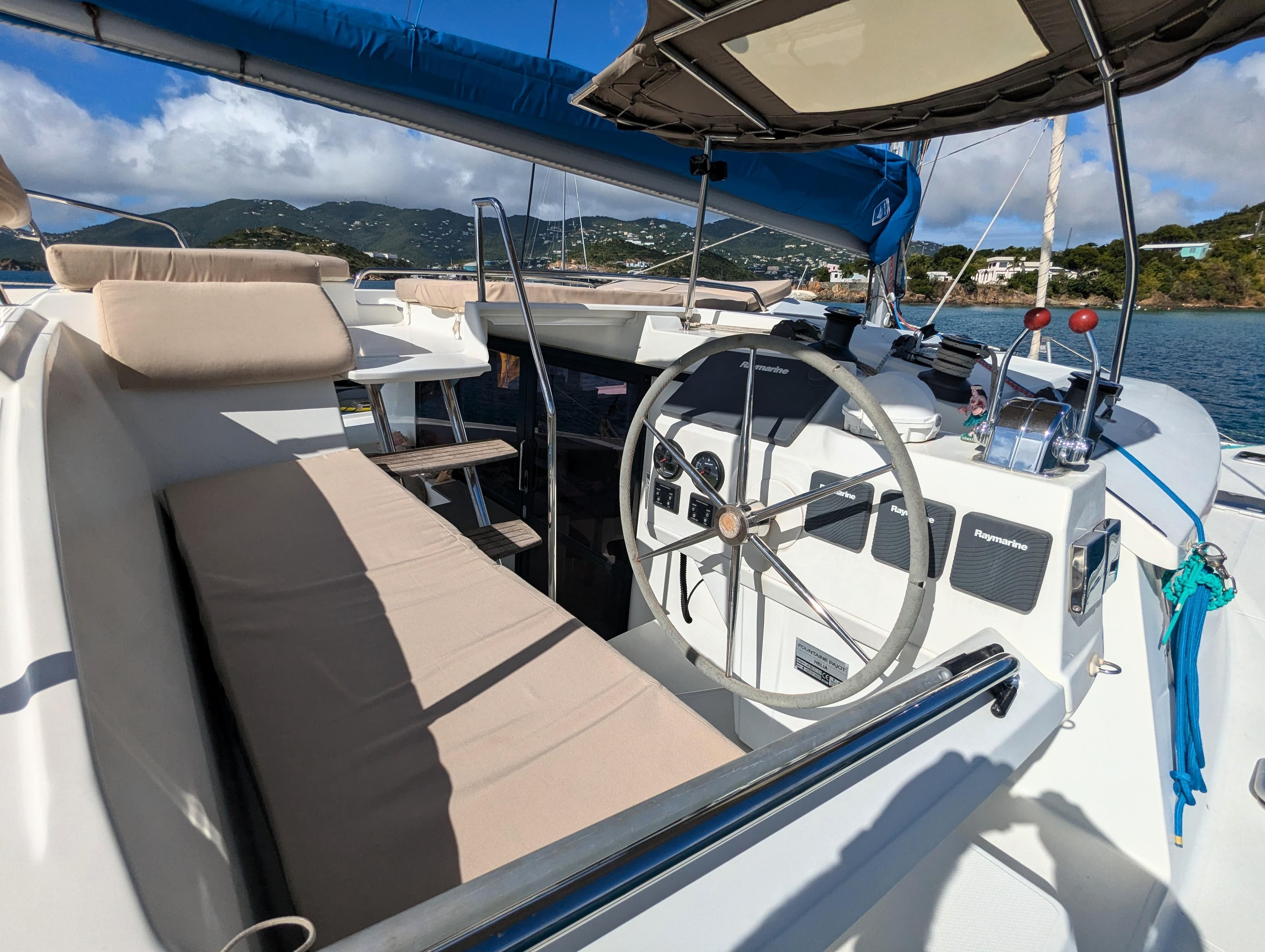 Helm of 2017 Fountaine Pajot Helia 44 Evolution catamaran with scenic ocean backdrop.