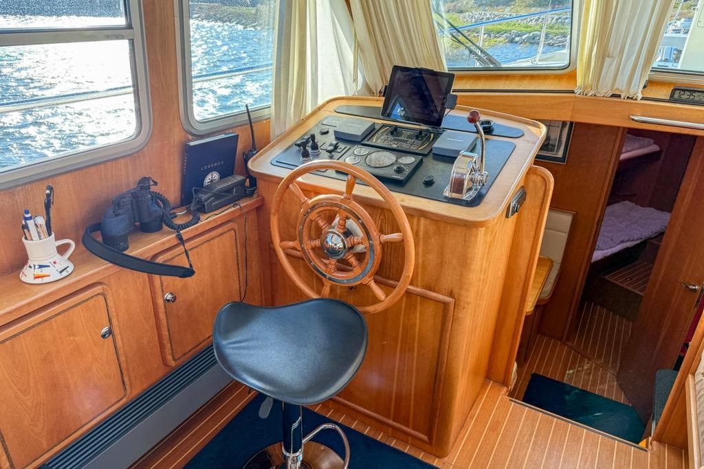 Helm of 2005 Linssen Grand Sturdy 410 AC with wooden steering wheel and navigation equipment.