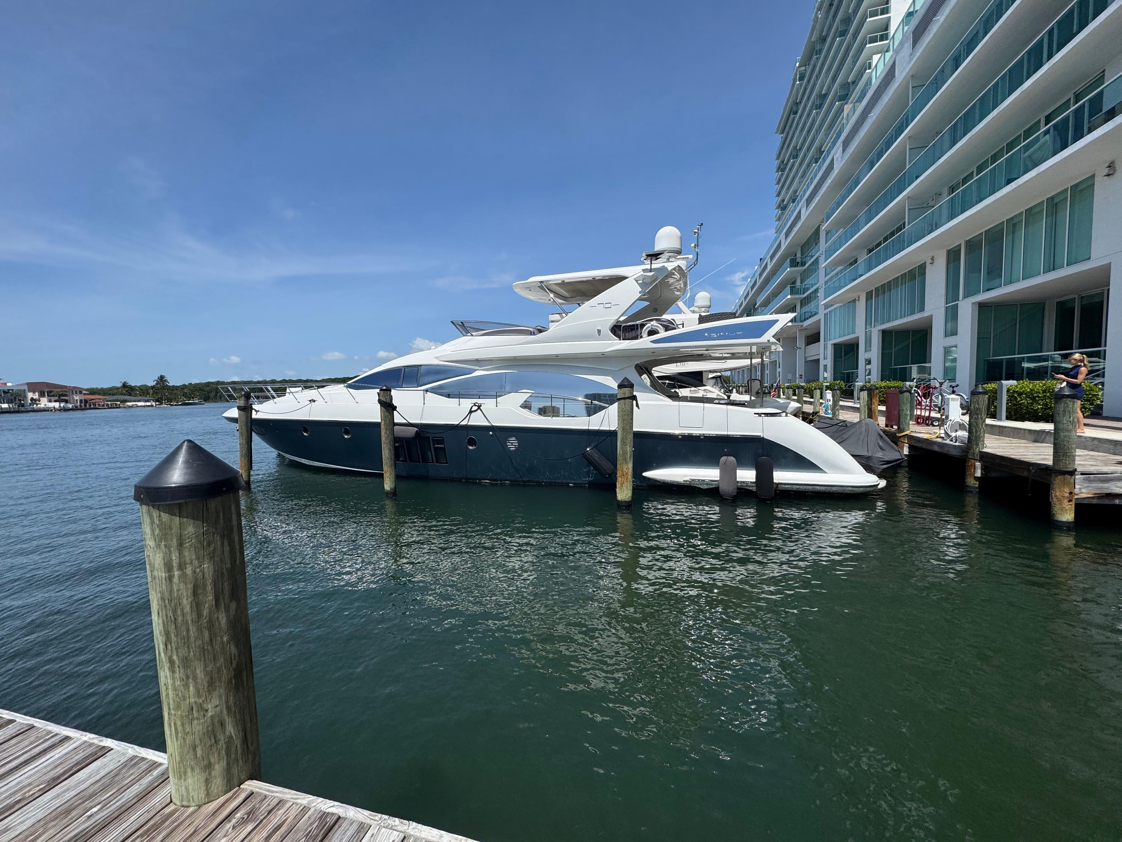 2014 Azimut Flybridge yacht docked beside modern waterfront building.