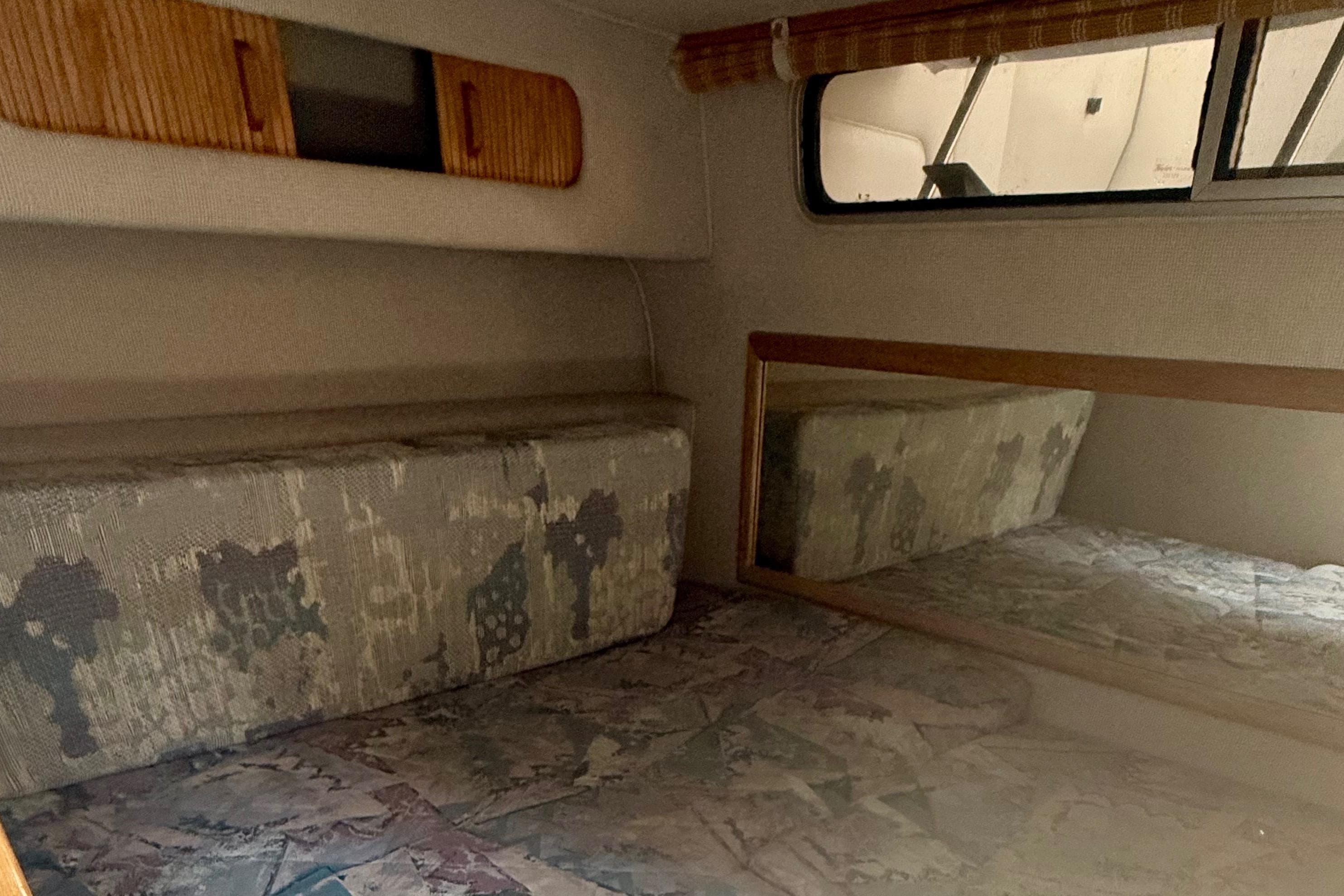 Interior cabin of 1992 Sea Ray 290 Sundancer with patterned upholstery and mirror.
