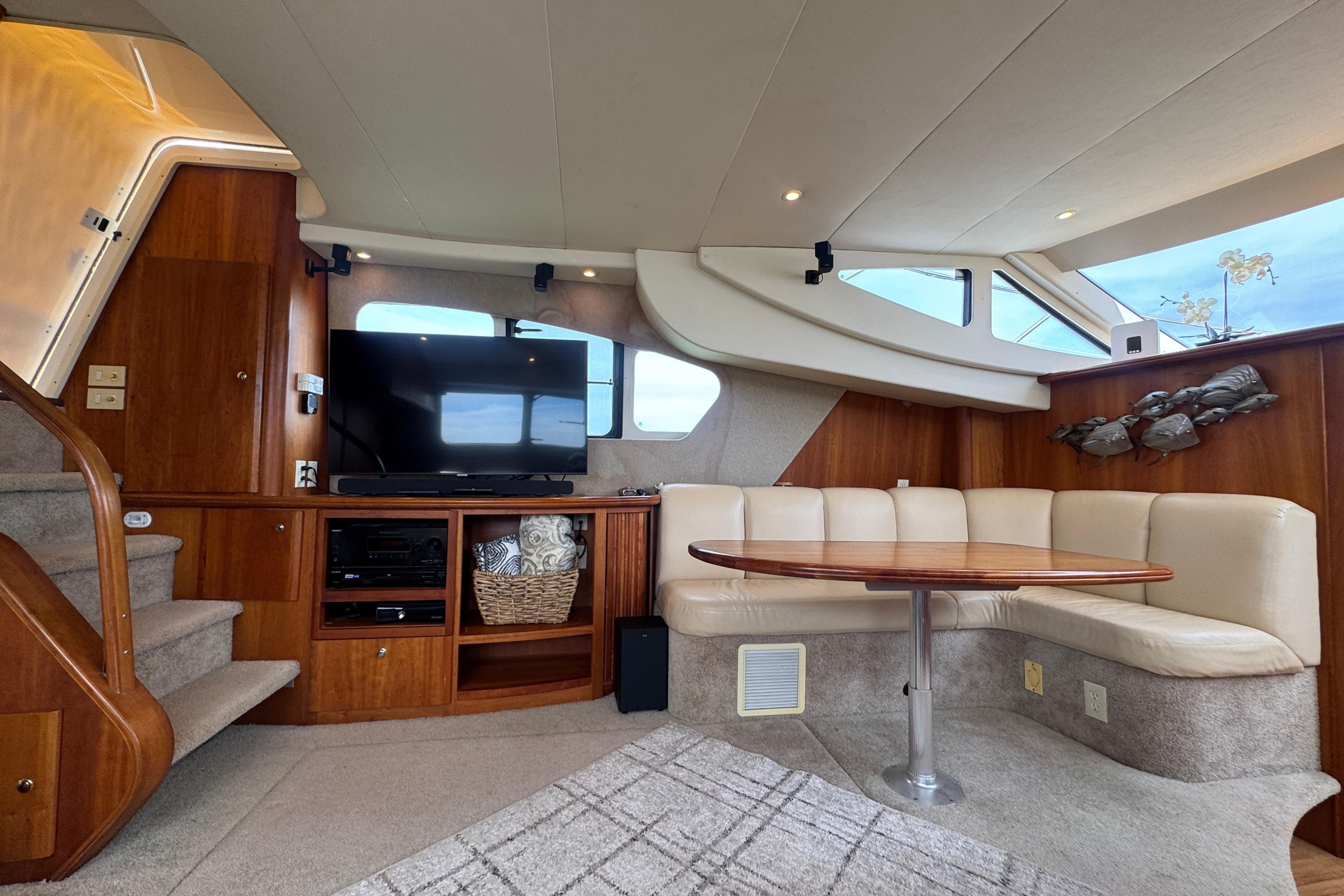 Luxurious interior of 2003 Silverton 39 Motor Yacht with TV, seating, and wooden accents.