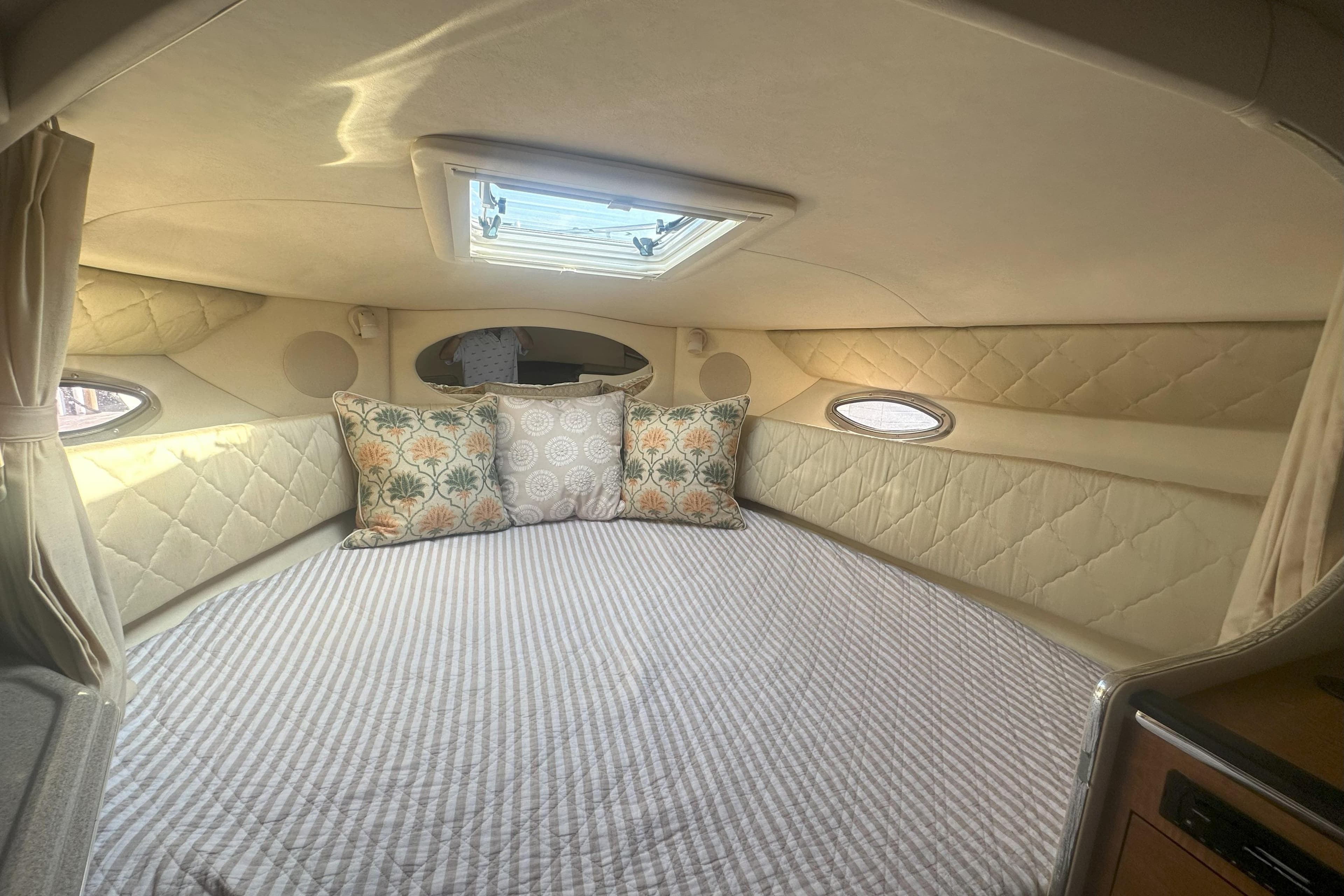 Interior cabin of 2006 Sea Ray 290 Amberjack with cozy bedding and decorative pillows.