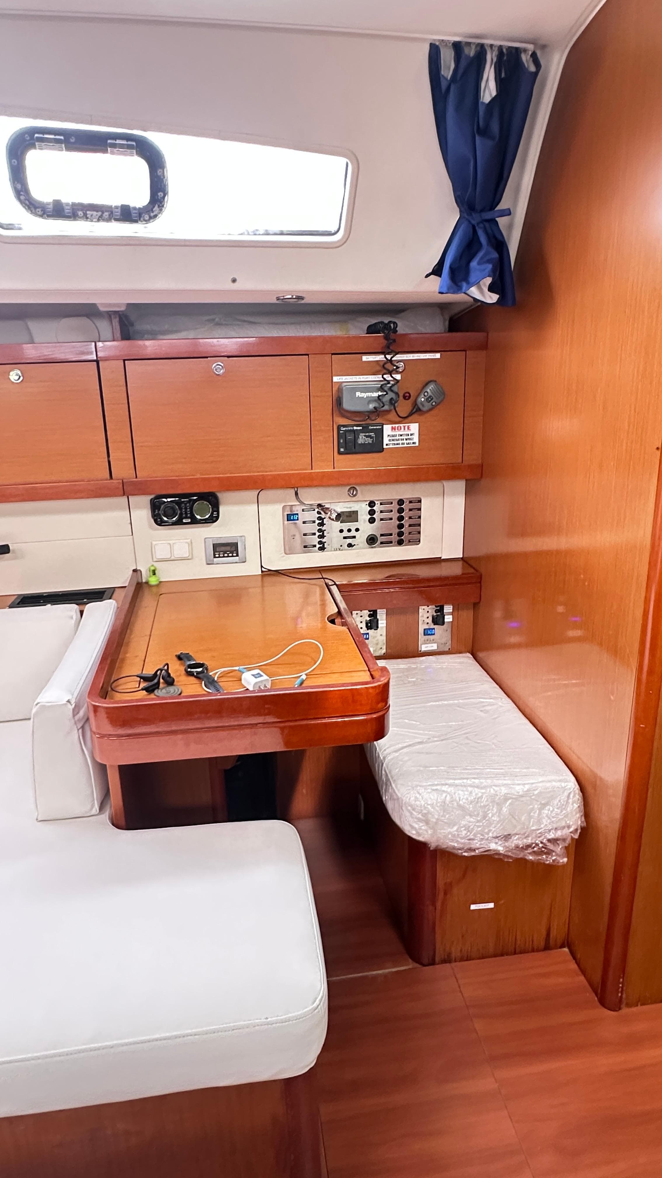 Interior of 2010 Beneteau Oceanis 50 yacht with wooden cabinetry and seating area.