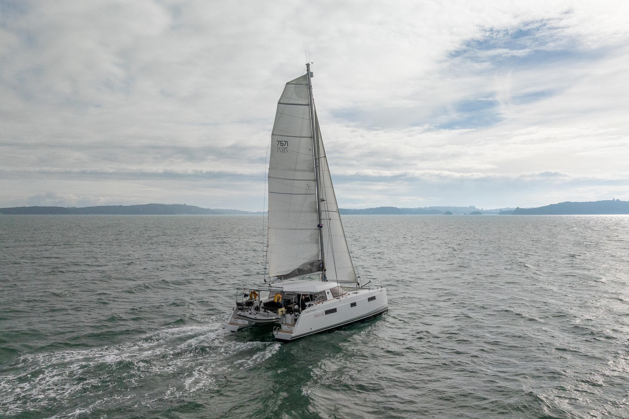 Sailing catamaran Nautitech 40 Open, 2015 model, cruising on open sea under cloudy skies.