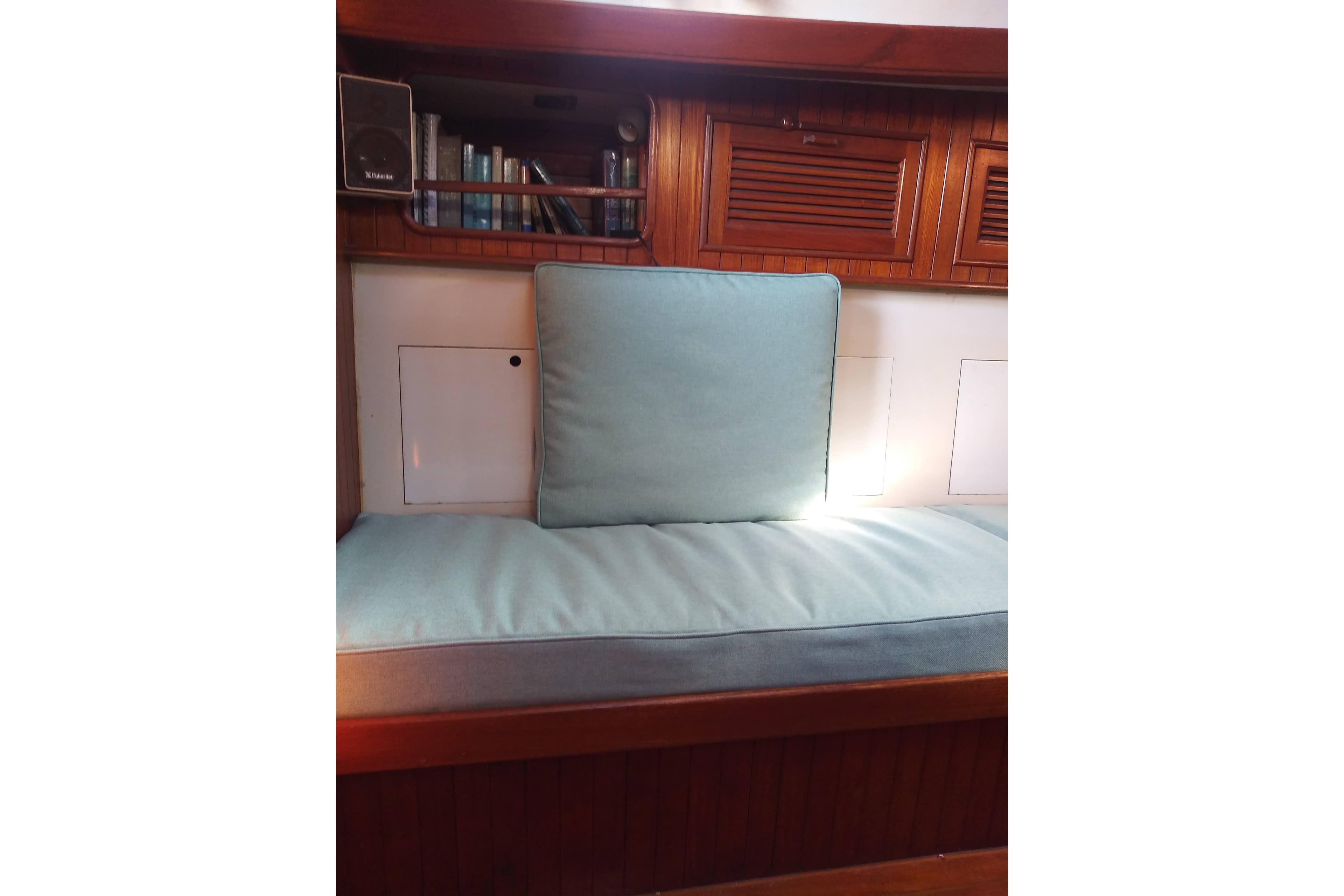 Interior of a 1978 Baba Cutter with cushioned seating and wooden cabinetry.