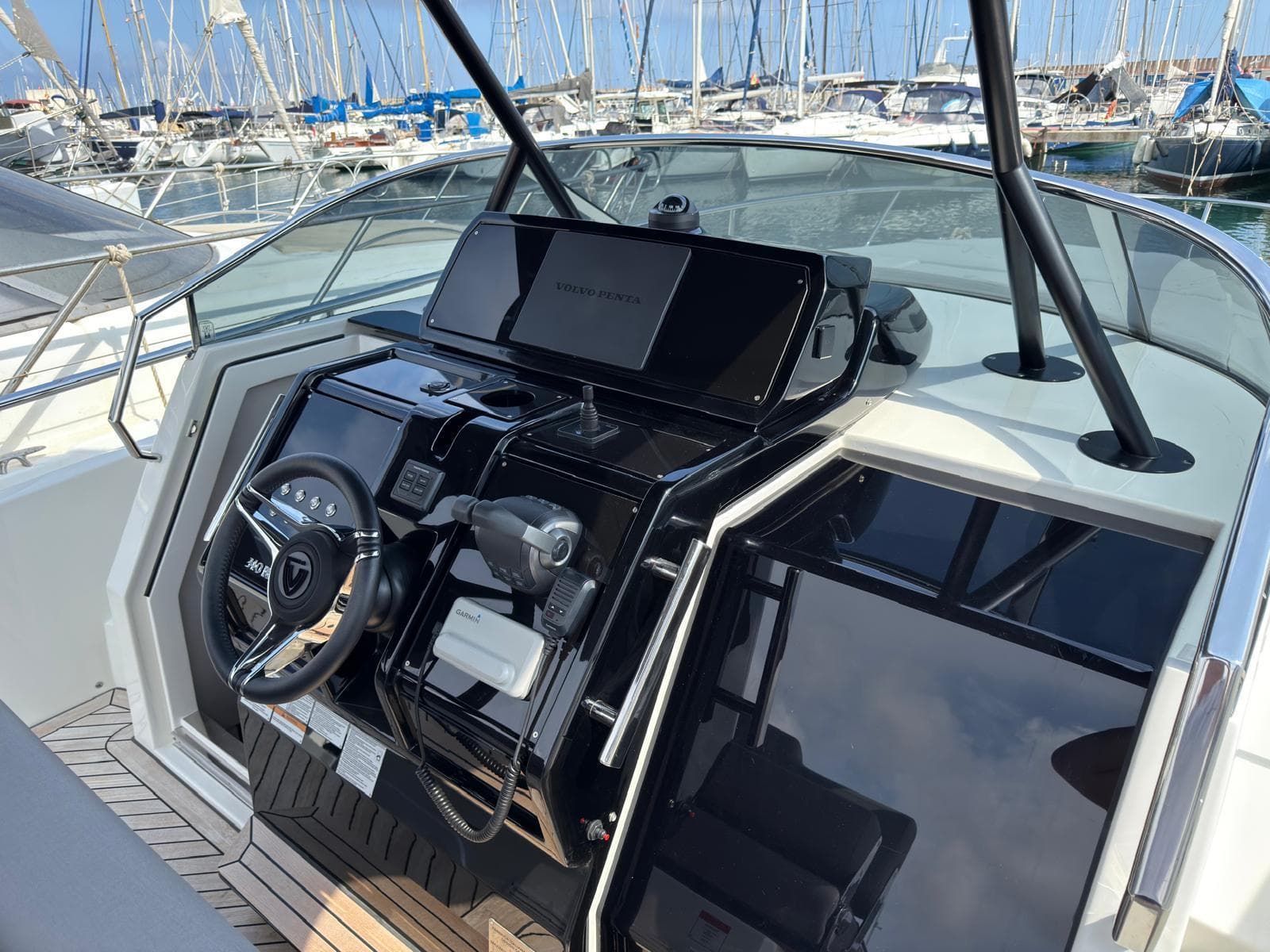 Helm of 2024 FIM 340 boat with modern controls and marina background.