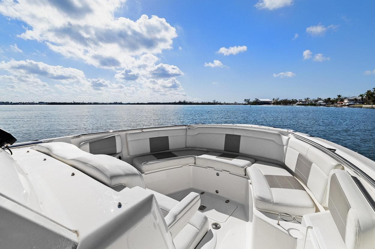 2021 Pursuit S 328 Sport boat with spacious seating, overlooking a serene water view.