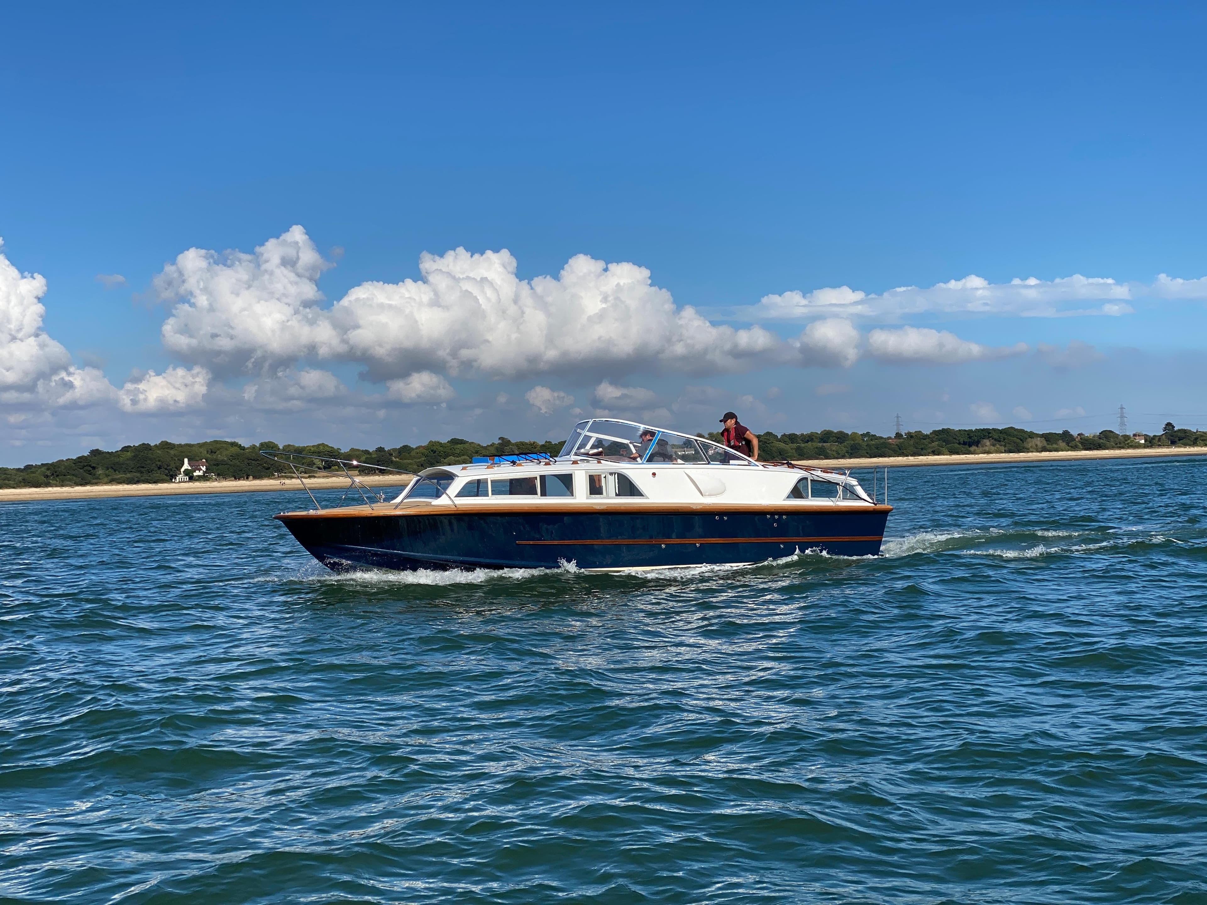1967 Fairey Huntsman 31 cruising on open water under a clear blue sky.
