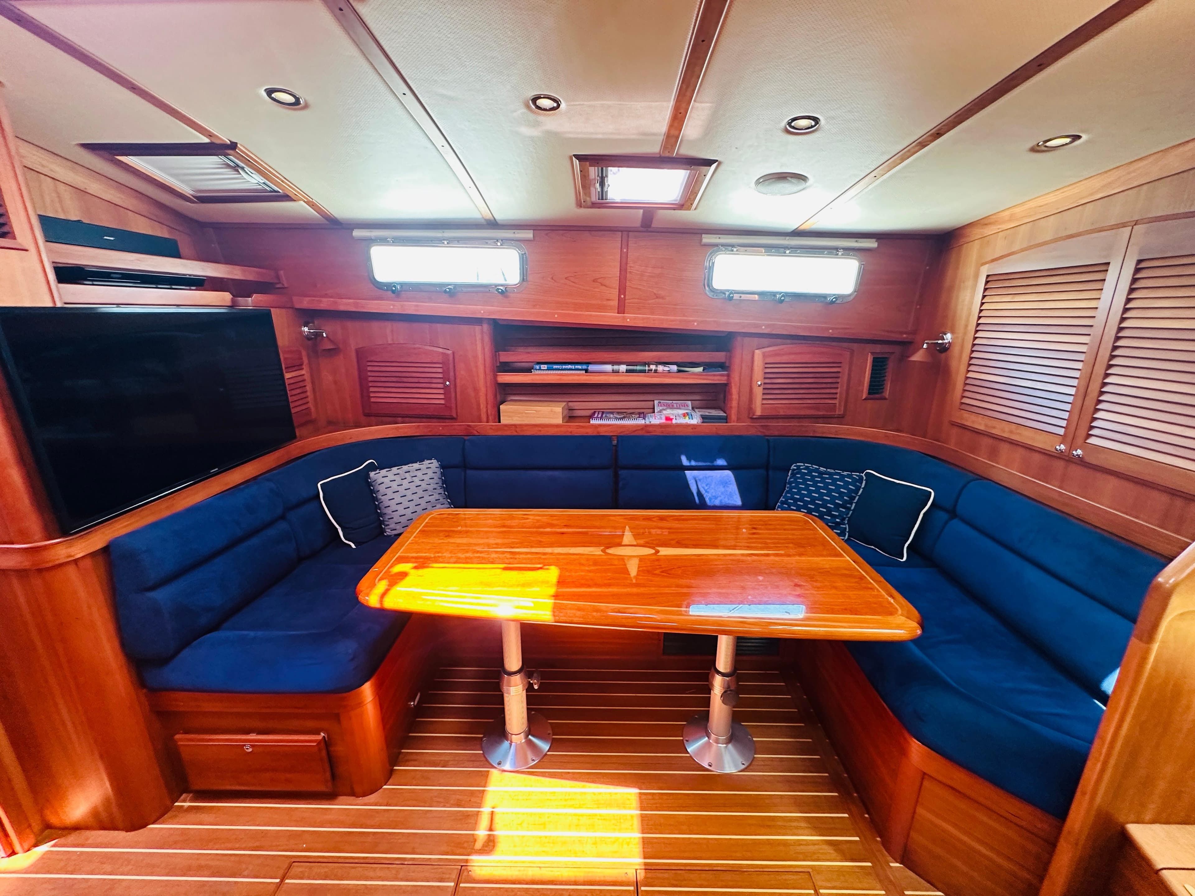 Luxurious interior of 2008 Sabre 42 Hardtop Express with wooden table and blue seating.