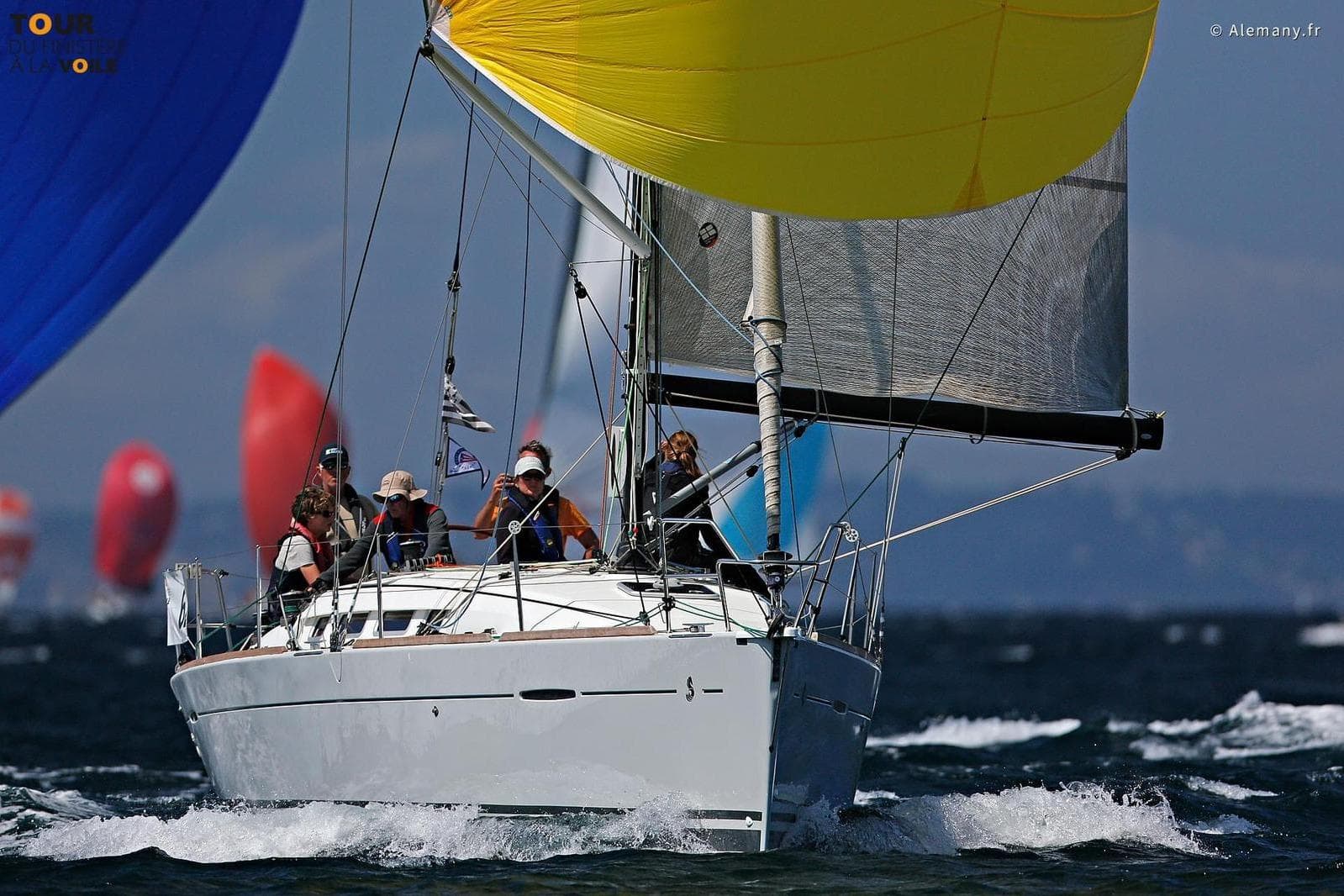 Sailing race featuring a 2011 Beneteau First 35 with colorful spinnakers in the background.
