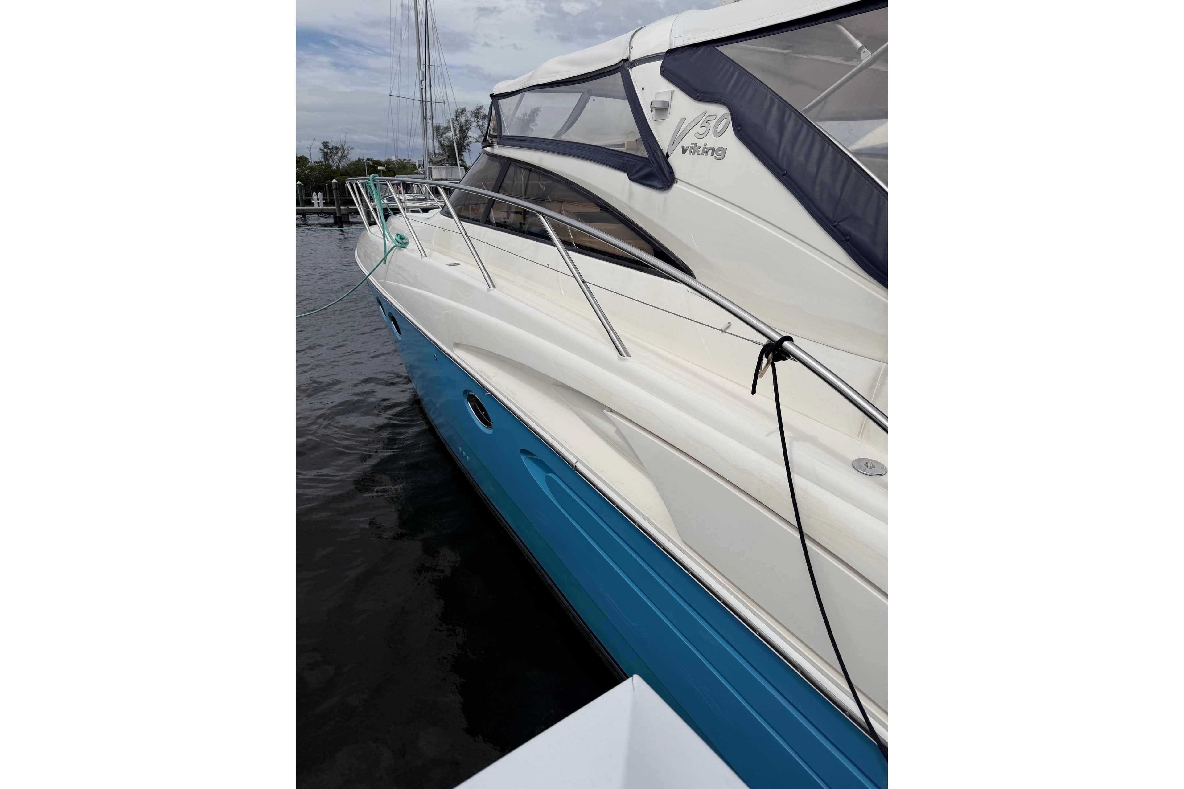 2003 Viking Princess V50 yacht docked, featuring sleek design and blue hull.