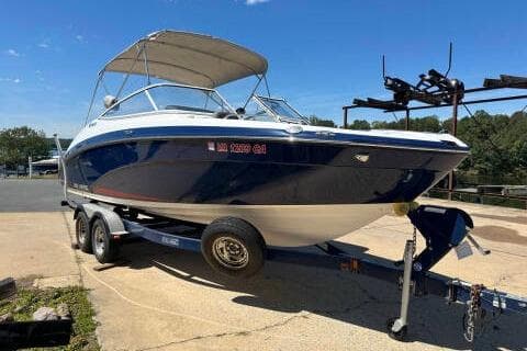 2016 Yamaha Boats 242 Limited E-Series on trailer, blue and white, parked outdoors.