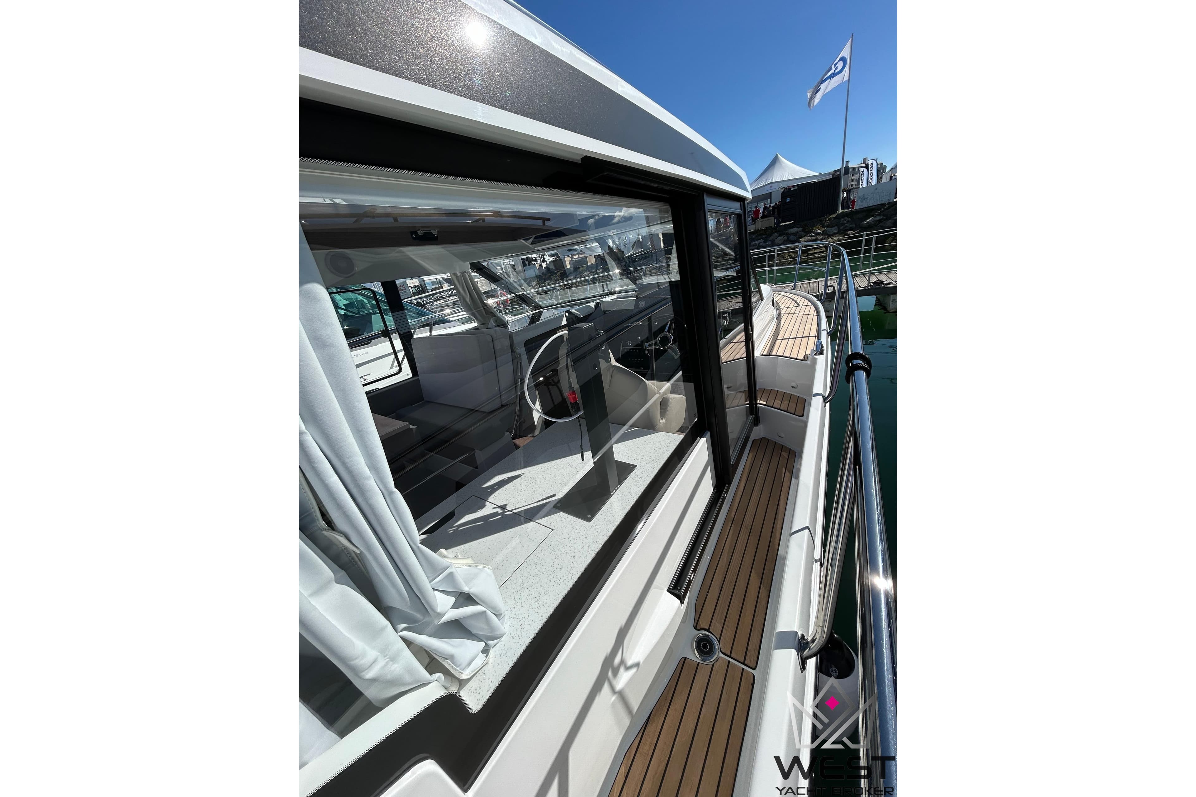 2026 Jeanneau Merry Fisher 1095 Fly Serie 2 yacht, side view with sleek design and wooden deck.