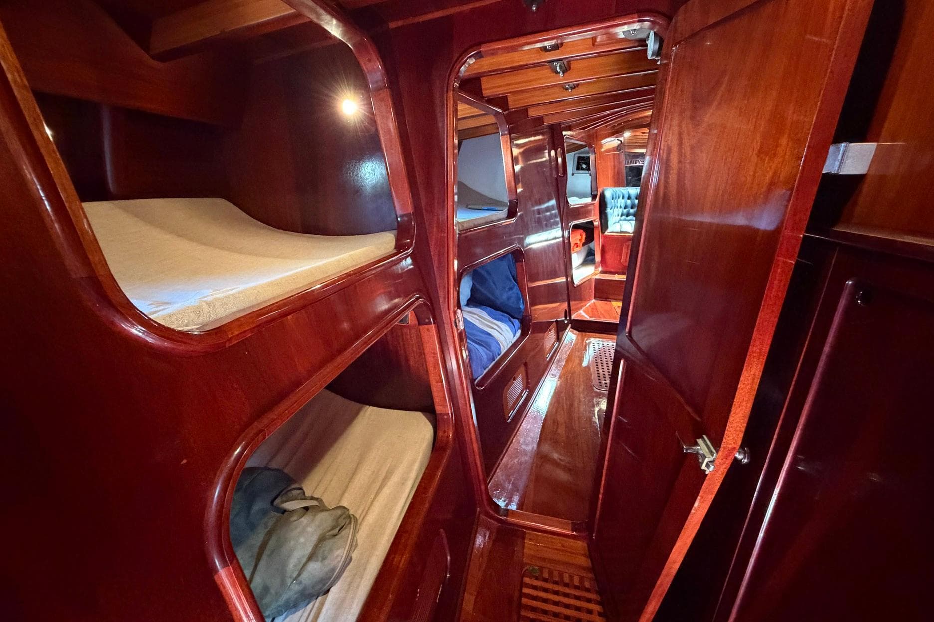 Luxurious wooden interior of a 1992 Vic Carpenter Custom yacht with cozy bunks.