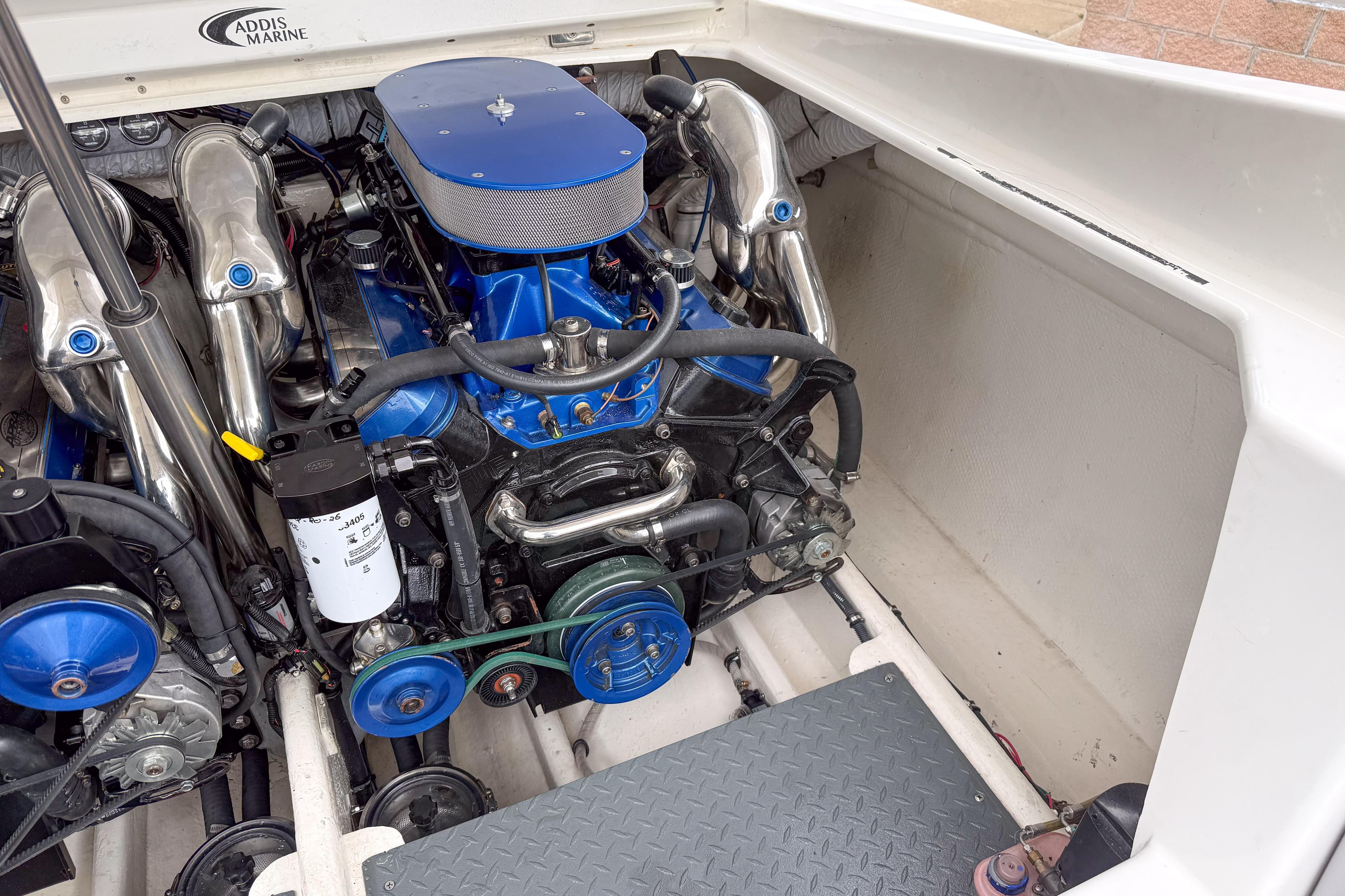 Engine compartment of a 2002 Active Thunder 37 boat, featuring a blue and chrome engine.