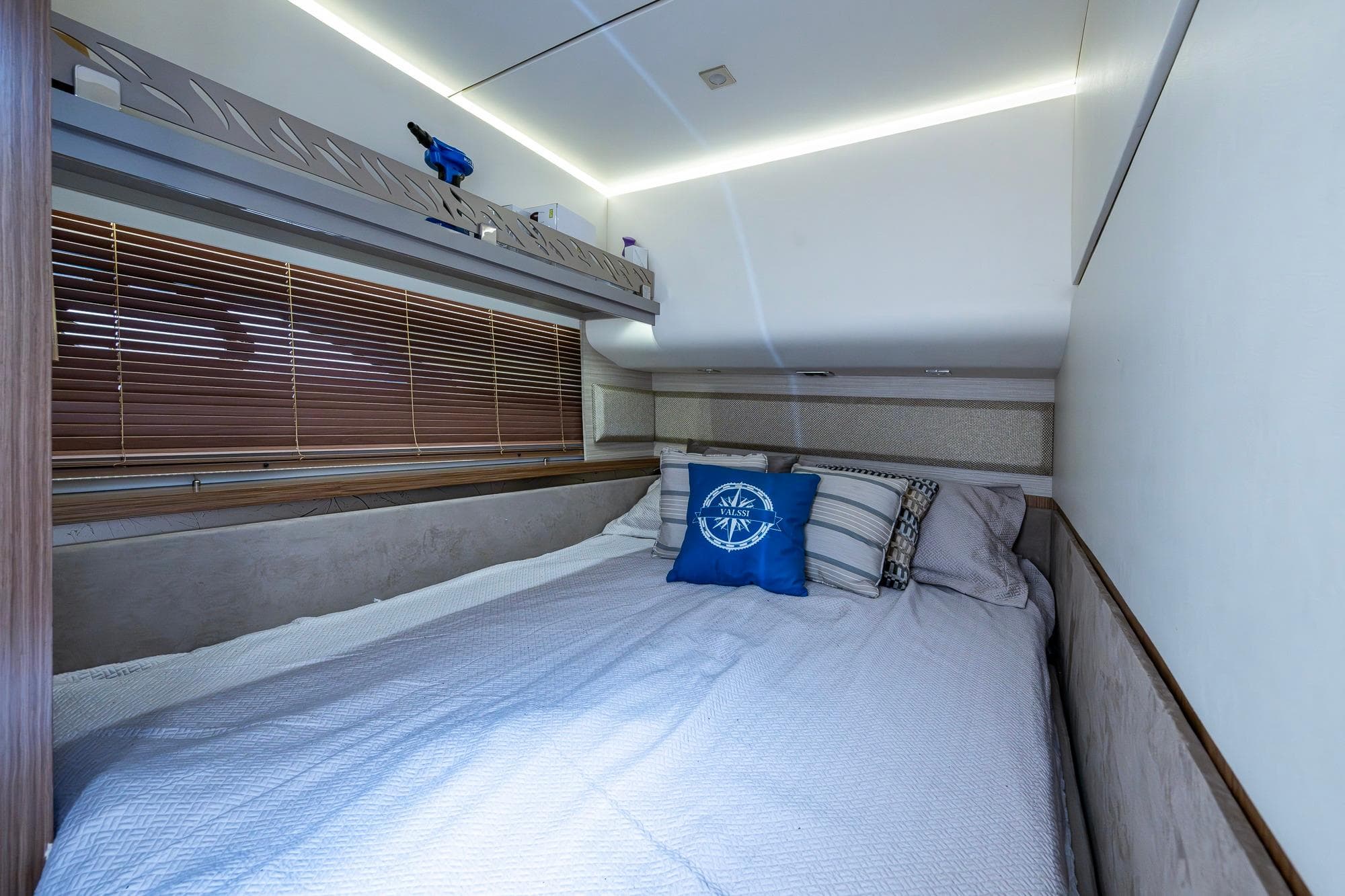 Luxurious bedroom interior of 2018 Sea Ray L550 Fly yacht with cozy bedding and nautical decor.