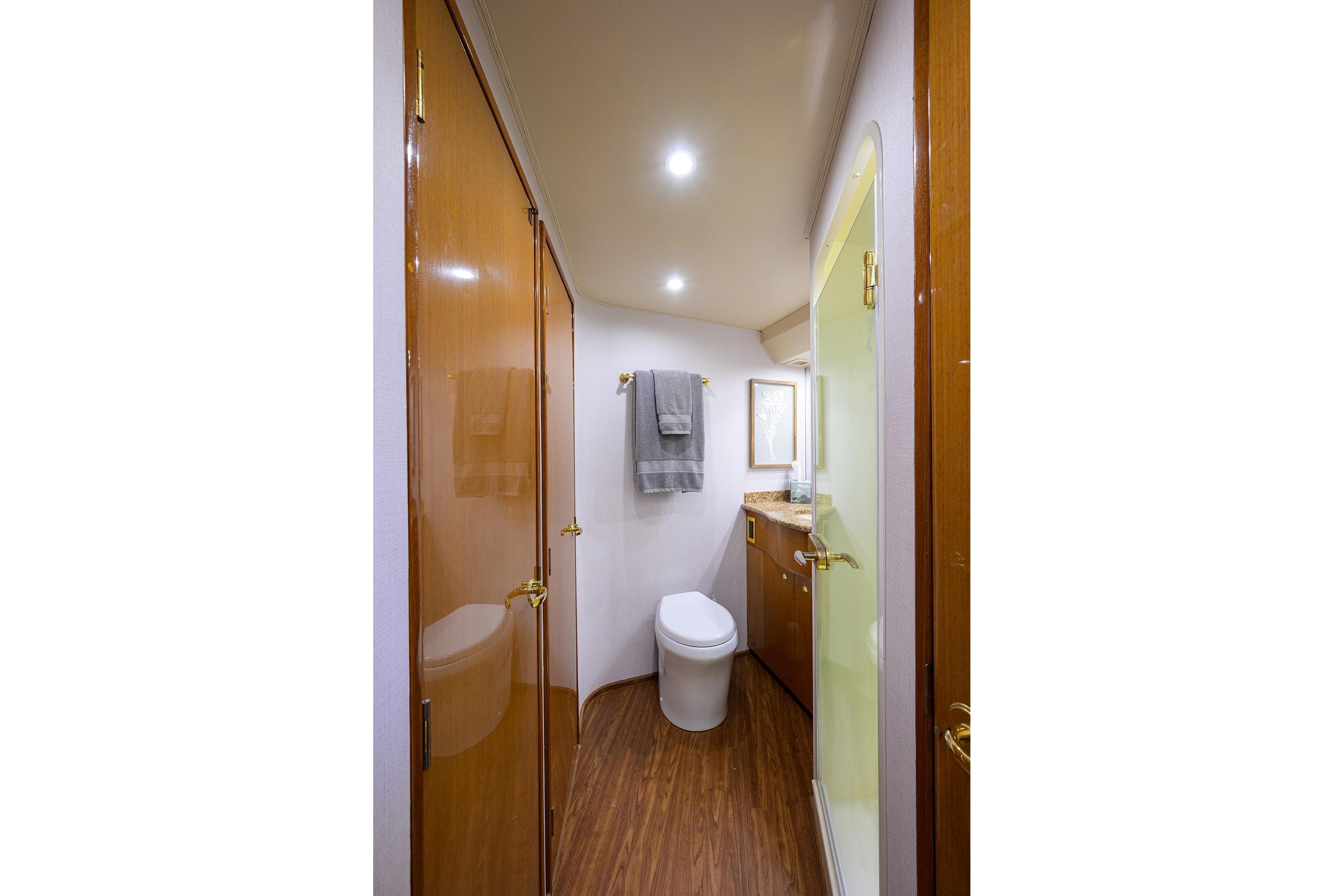 Luxurious bathroom interior of 2004 Viking 56 Convertible yacht, featuring wood accents and modern fixtures.