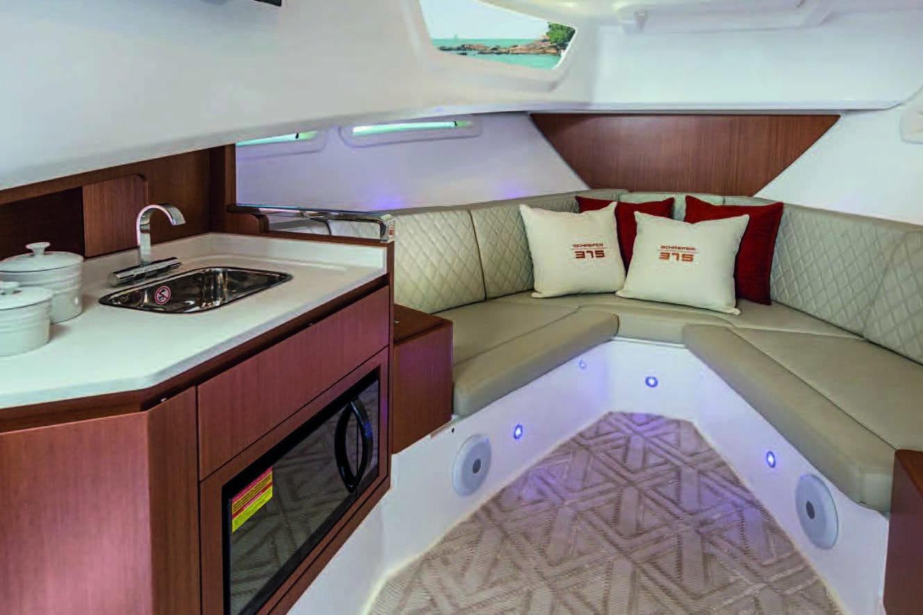 Luxurious interior of 2025 Schaefer 375 HT yacht with modern kitchenette and cozy seating area.