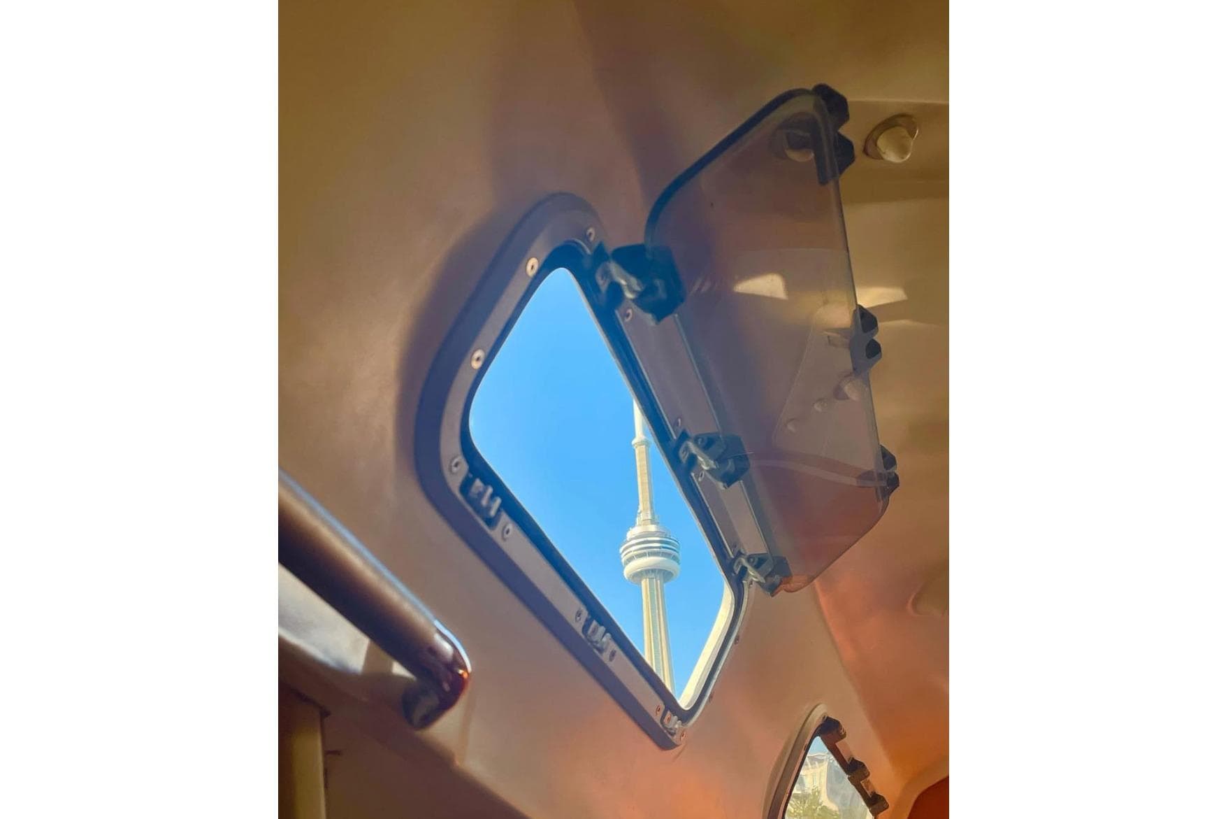 Open hatch view from 2008 Beneteau First 10R, showcasing a tower against blue sky.