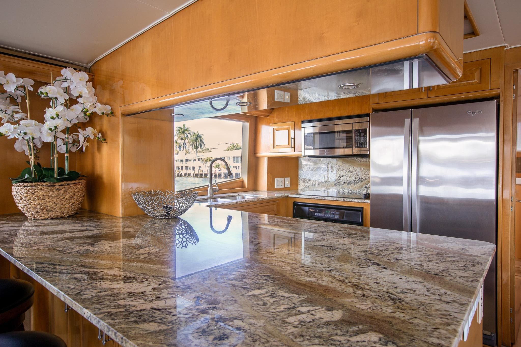 Luxurious kitchen interior of 2001 Hatteras 75 Cockpit Motor Yacht with granite countertops.