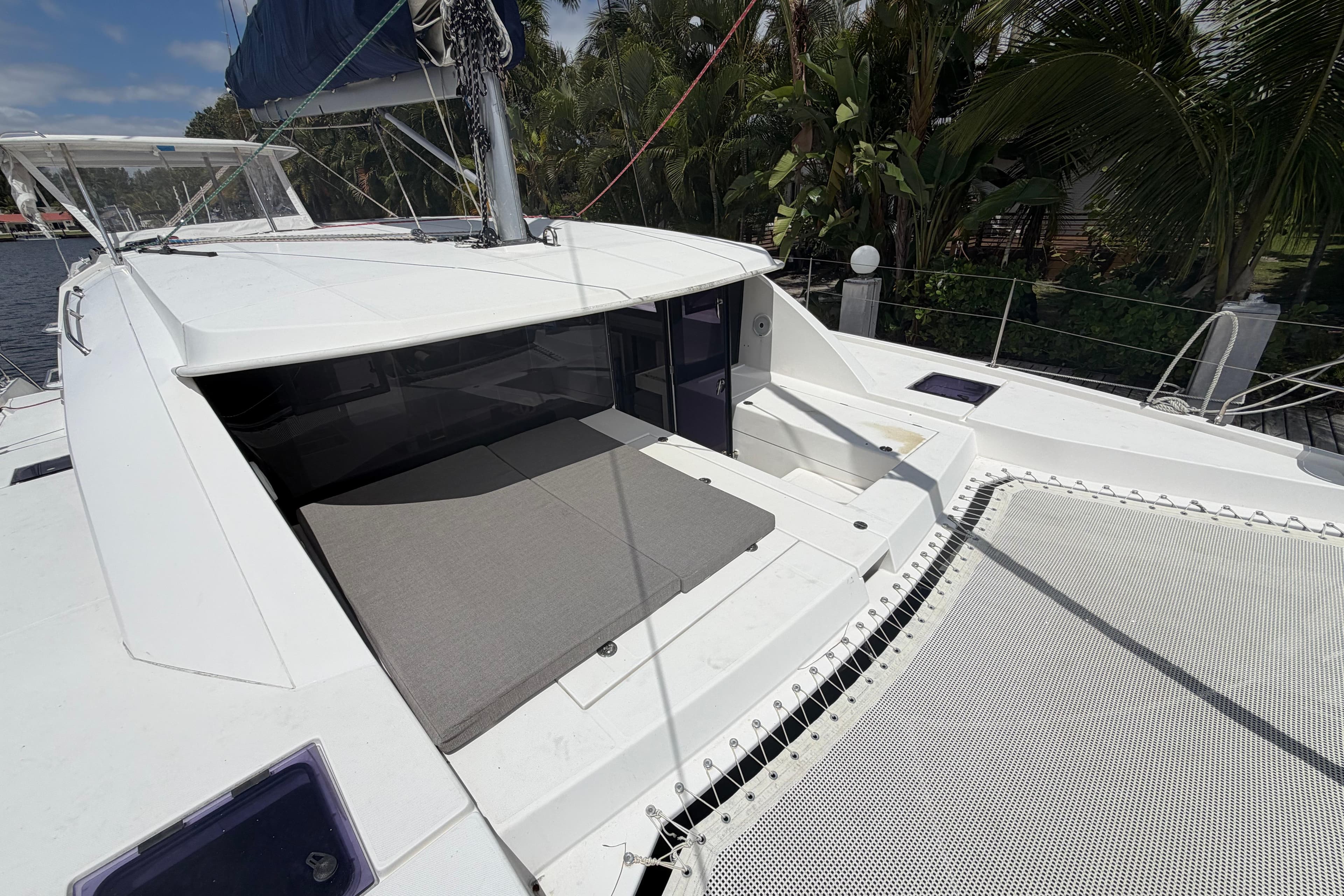 2018 Leopard 40 catamaran deck with seating and netting, surrounded by tropical foliage.