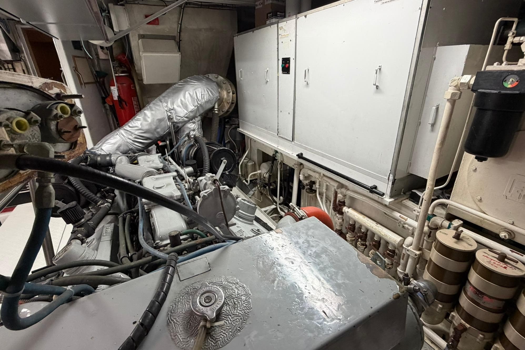 Engine room of a 1990 Lowland Netship 97, showcasing machinery and piping systems.