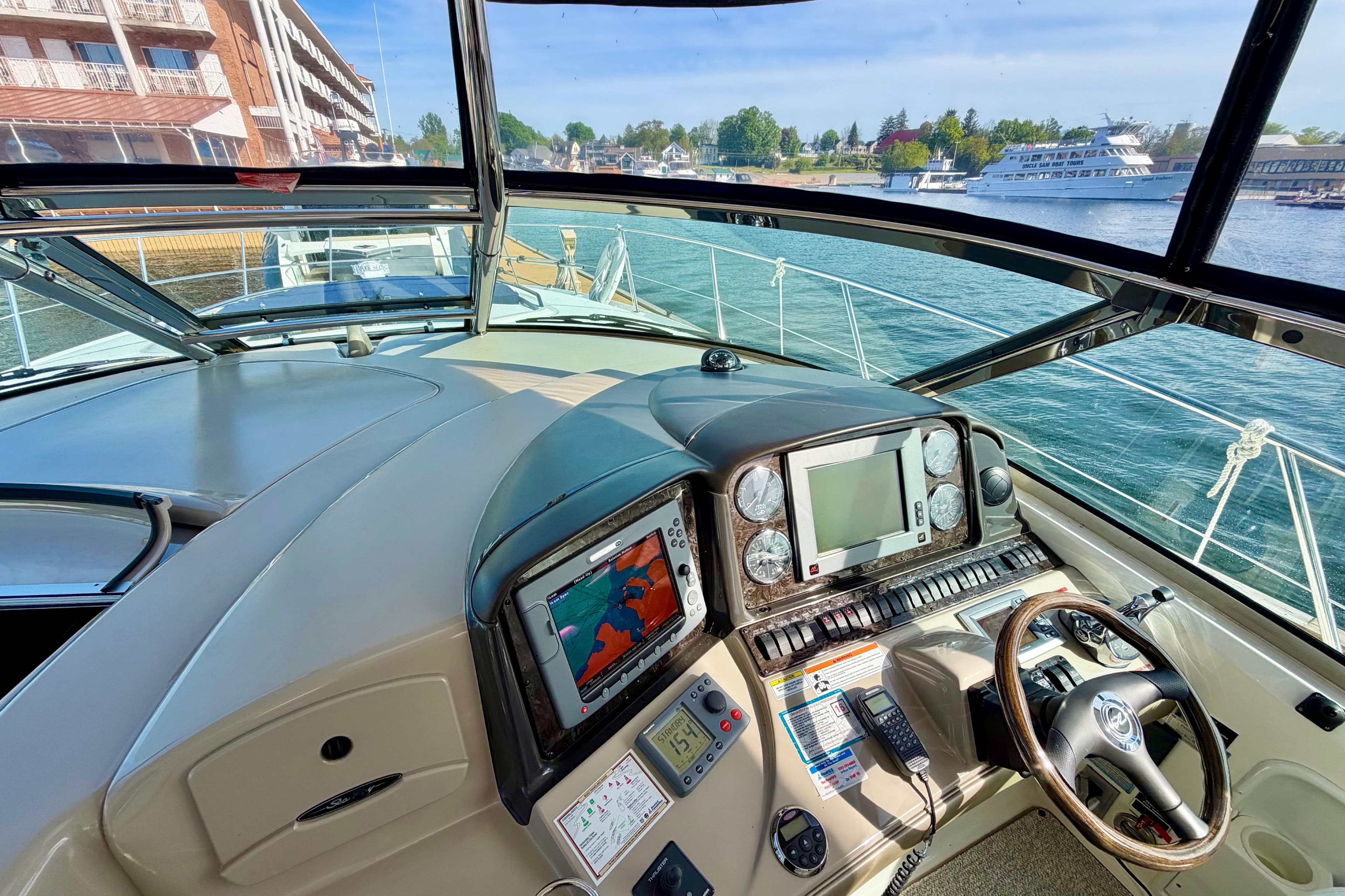 Helm of 2008 Sea Ray 44 Sundancer yacht with navigation equipment and waterfront view.