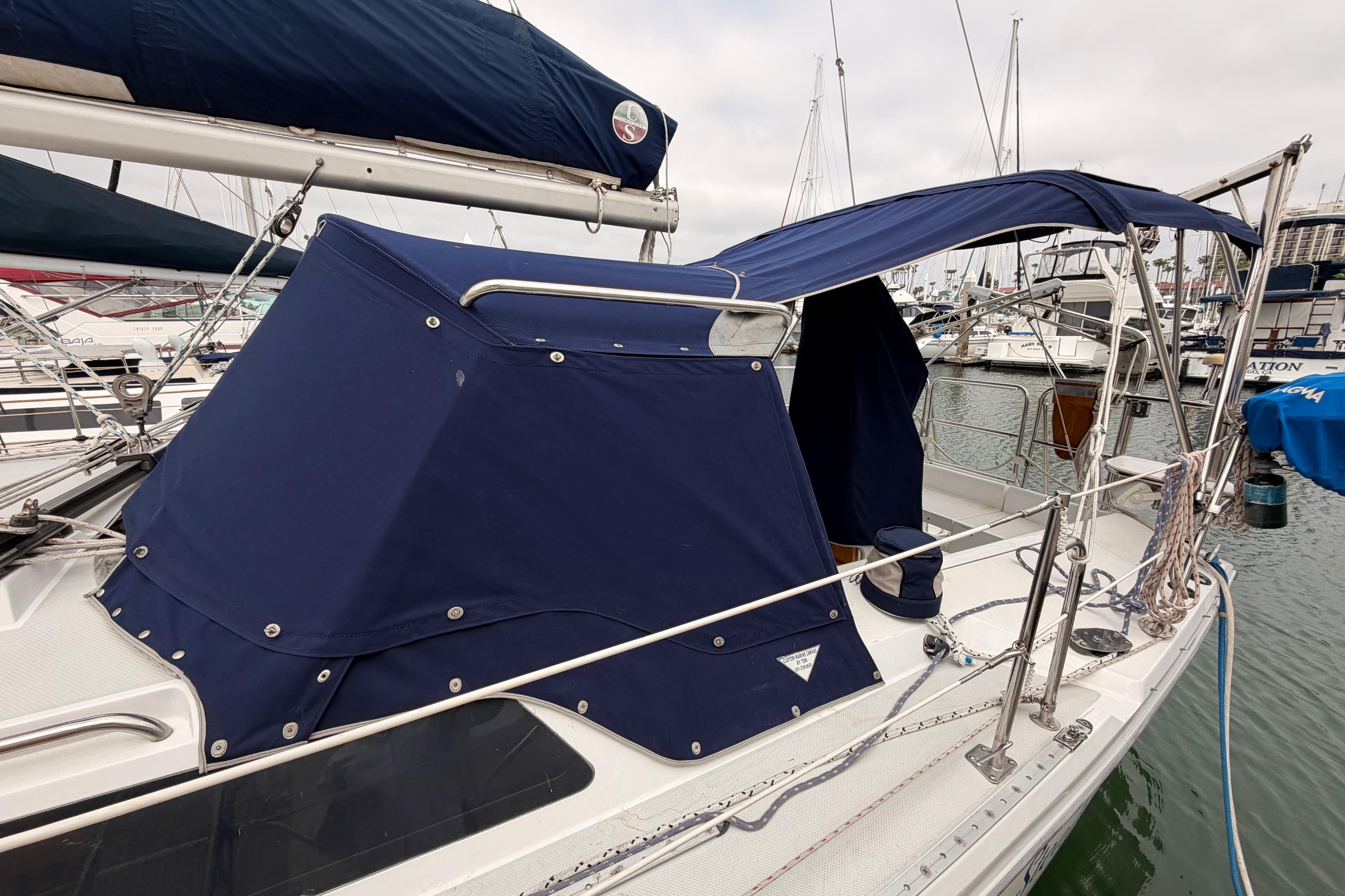 1996 Catalina 36 MkII sailboat with blue canvas cover docked at marina.