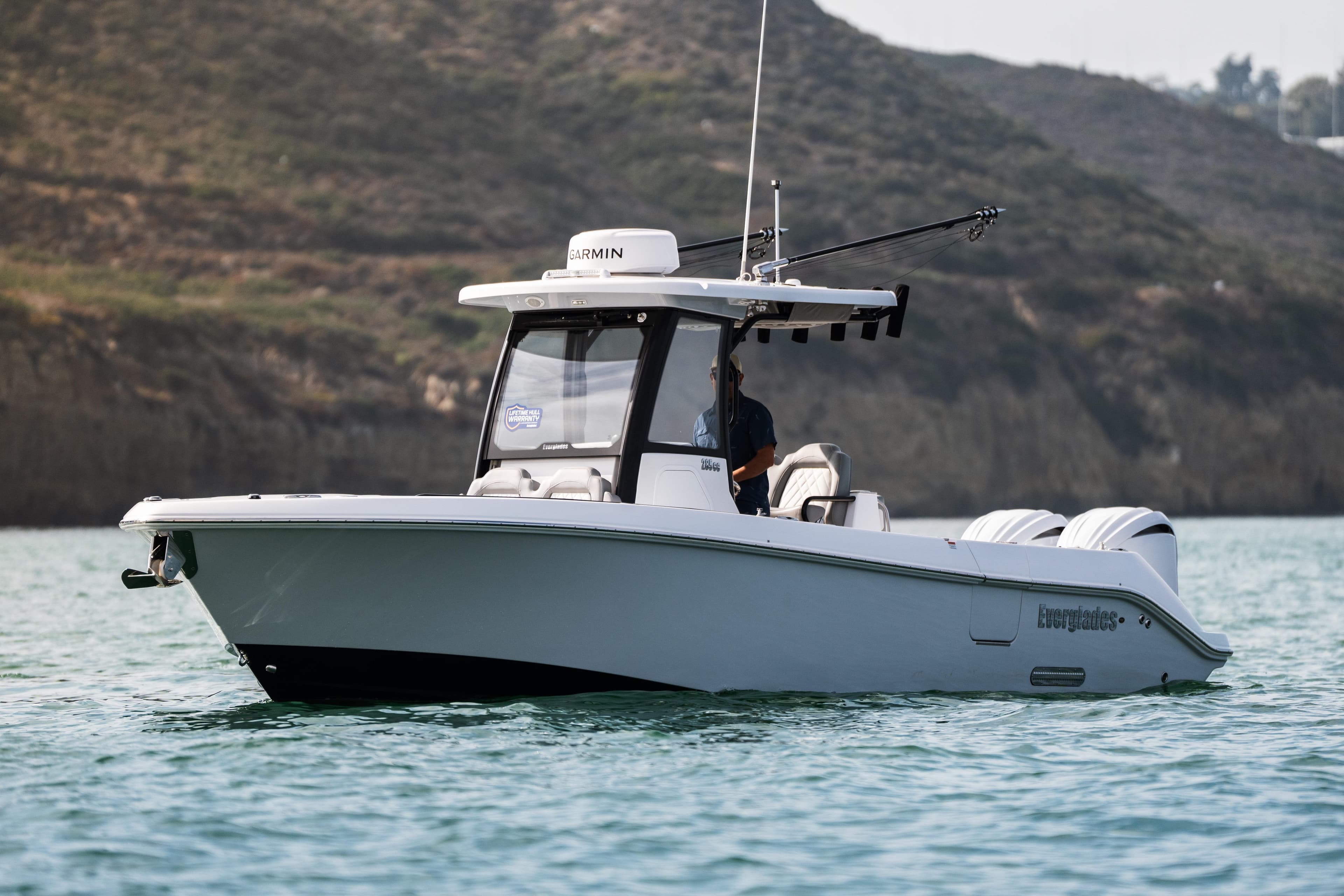 2025 Everglades 285 Center Console boat on calm water, scenic background.