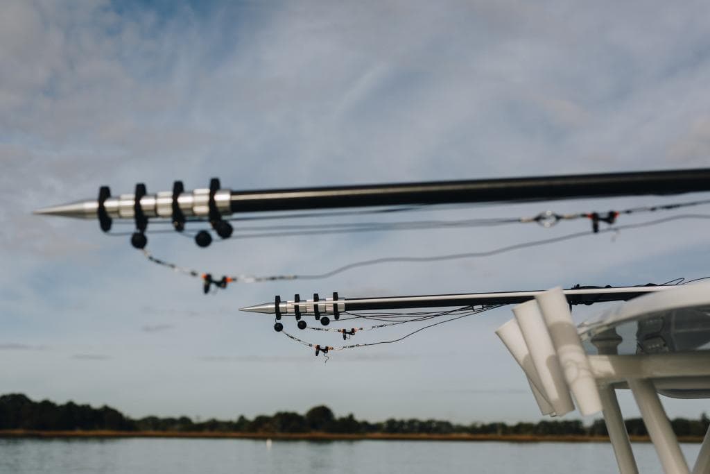 Outriggers on a 2023 Yellowfin 32 Offshore boat against a cloudy sky.
