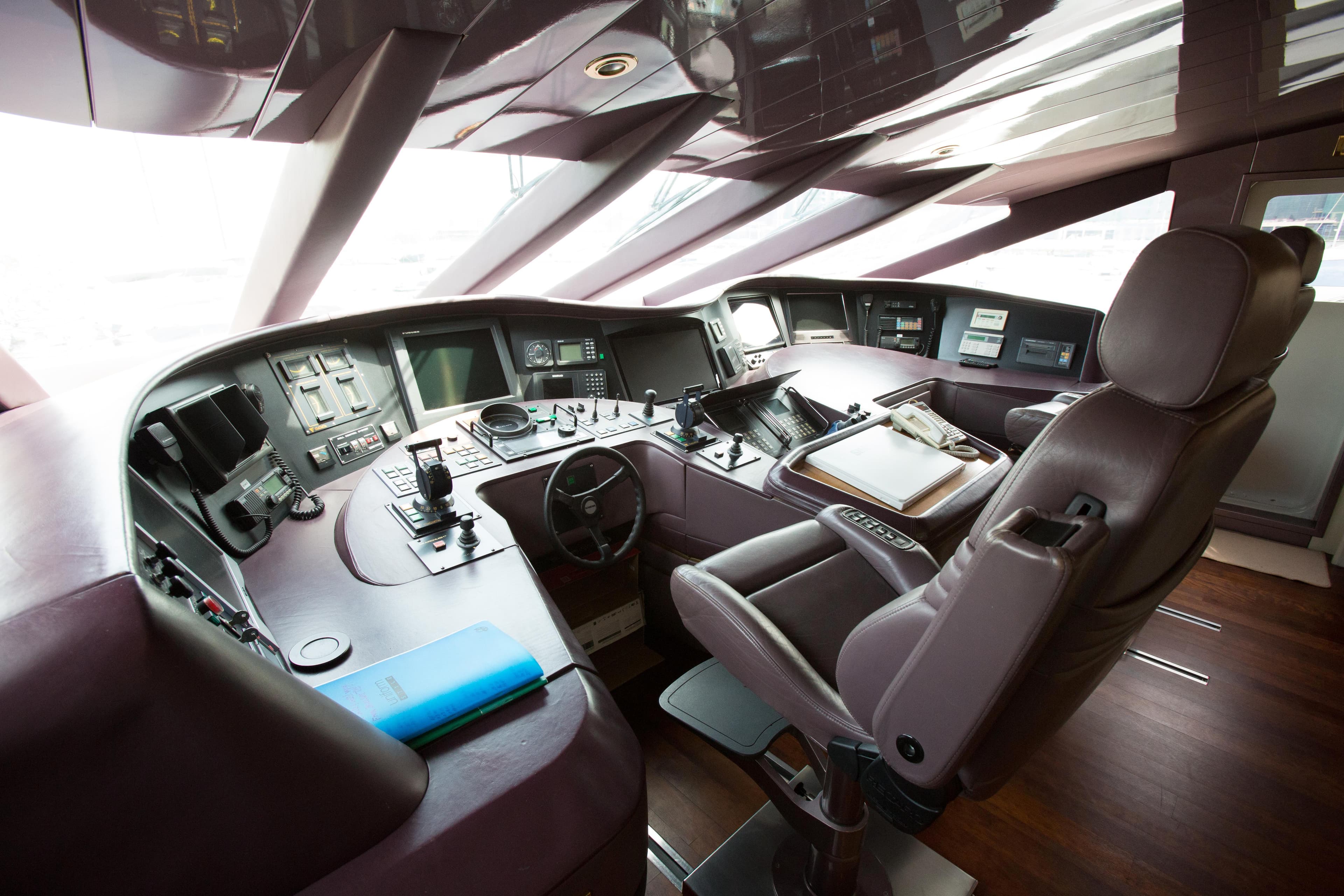 Cockpit of a 1998 Trident 127 yacht with advanced navigation controls and luxurious seating.