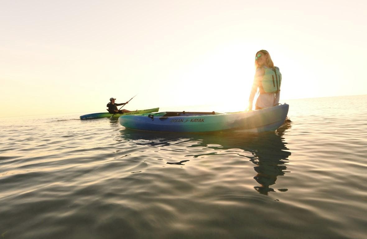 Two people kayaking on calm water at sunset, Ocean Kayak Malibu 11.5, 2023.