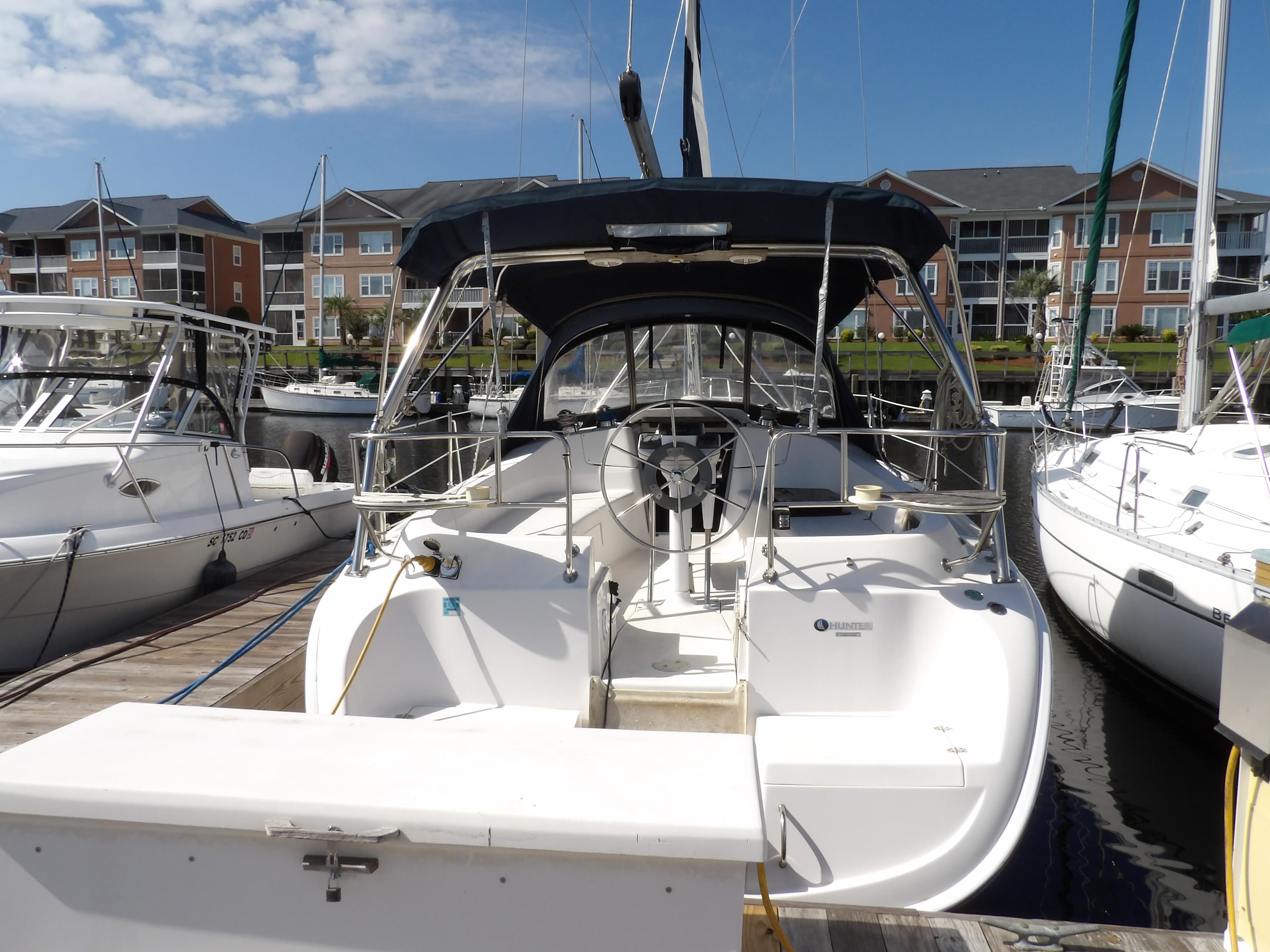 2002 Hunter 356 sailboat docked at marina with clear sky.