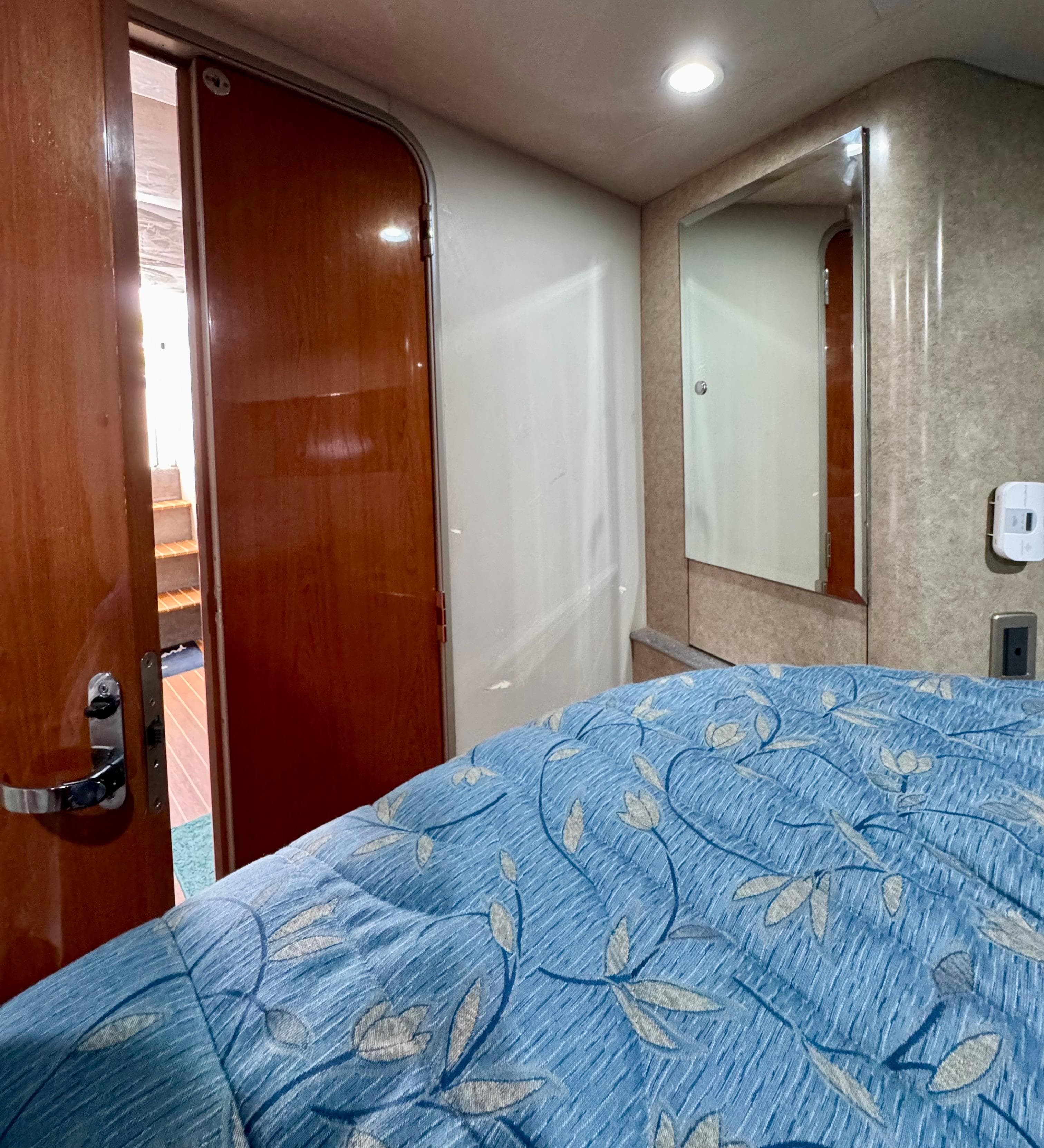 Interior cabin of a 2006 Formula 40pc boat with blue floral bedding.