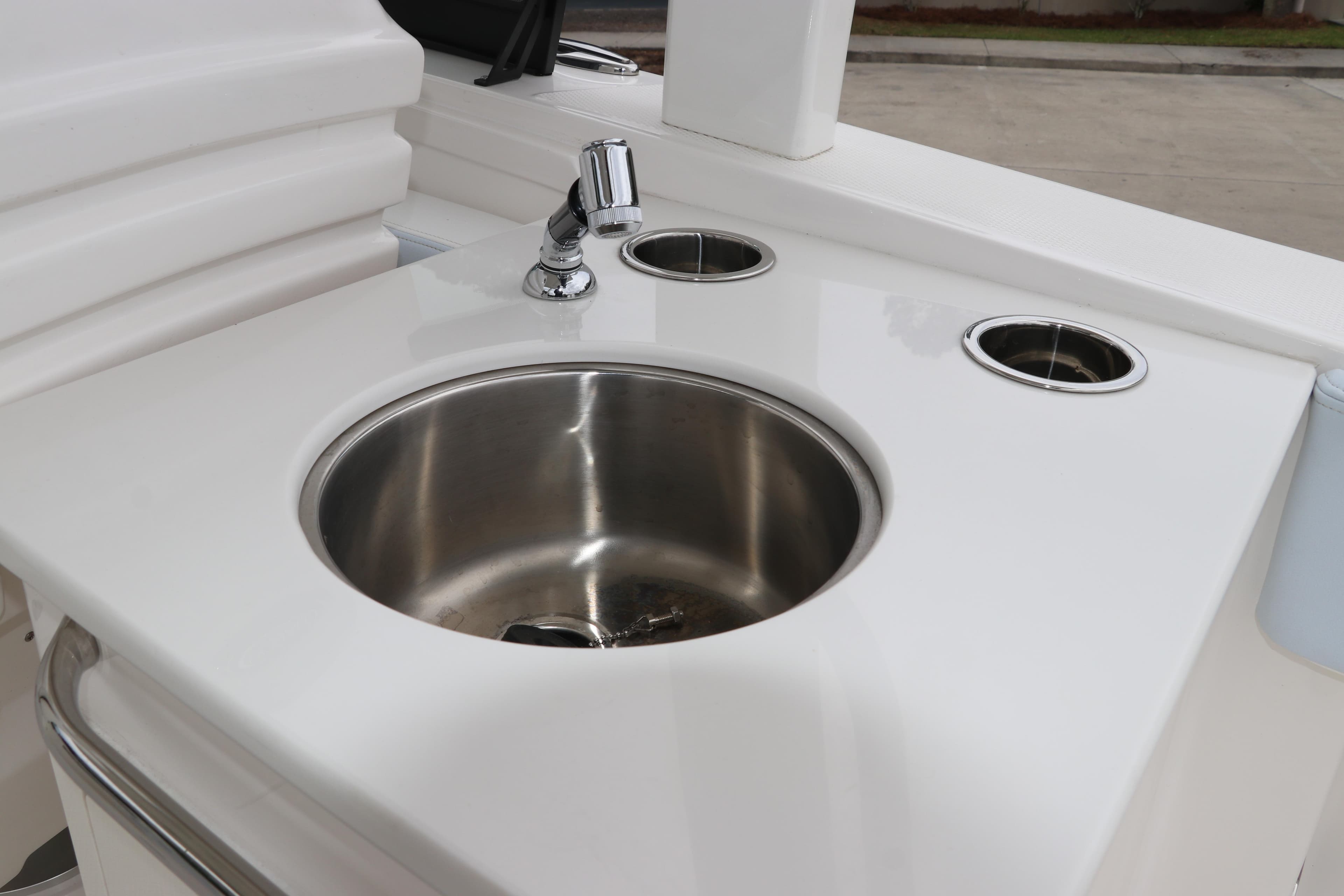 2026 Robalo R257 Dual Console boat sink with faucet and cup holders.