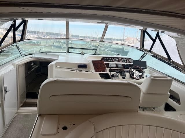 Interior view of 1995 Sea Ray 450 Sundancer yacht cockpit with steering wheel and controls.