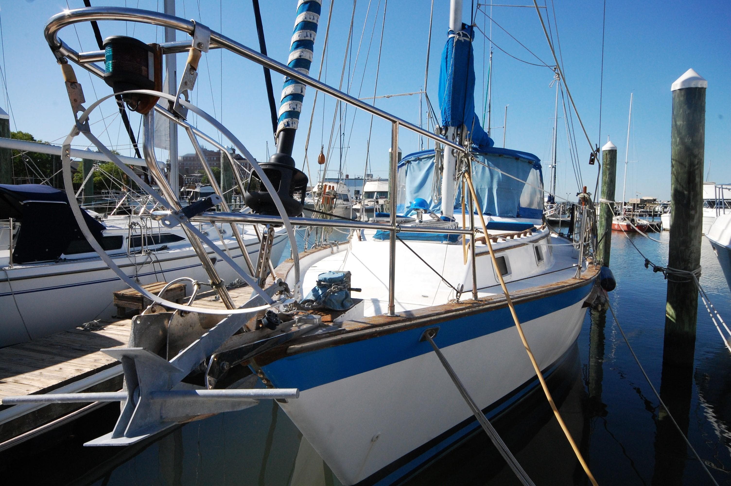 1981 Endeavour 40 sailboat docked at a marina under clear blue skies.