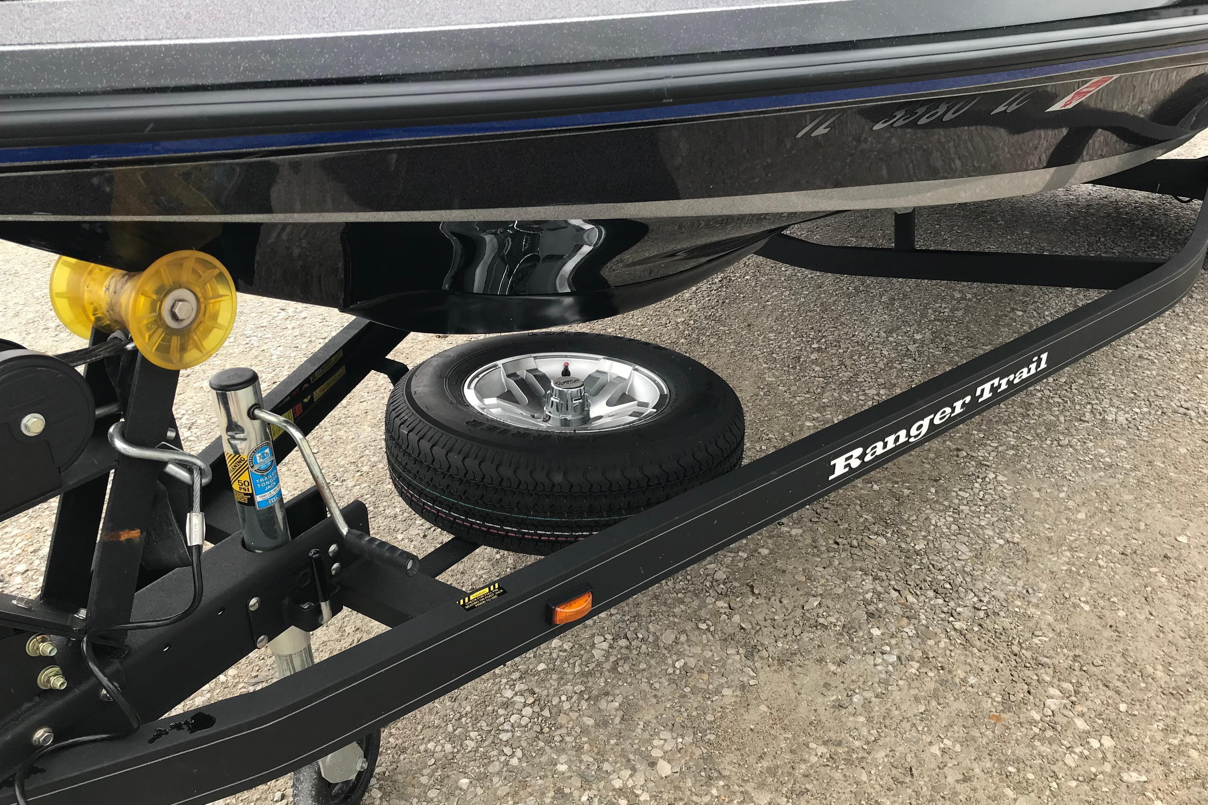 2022 Ranger Z185 boat trailer with spare tire on gravel surface.