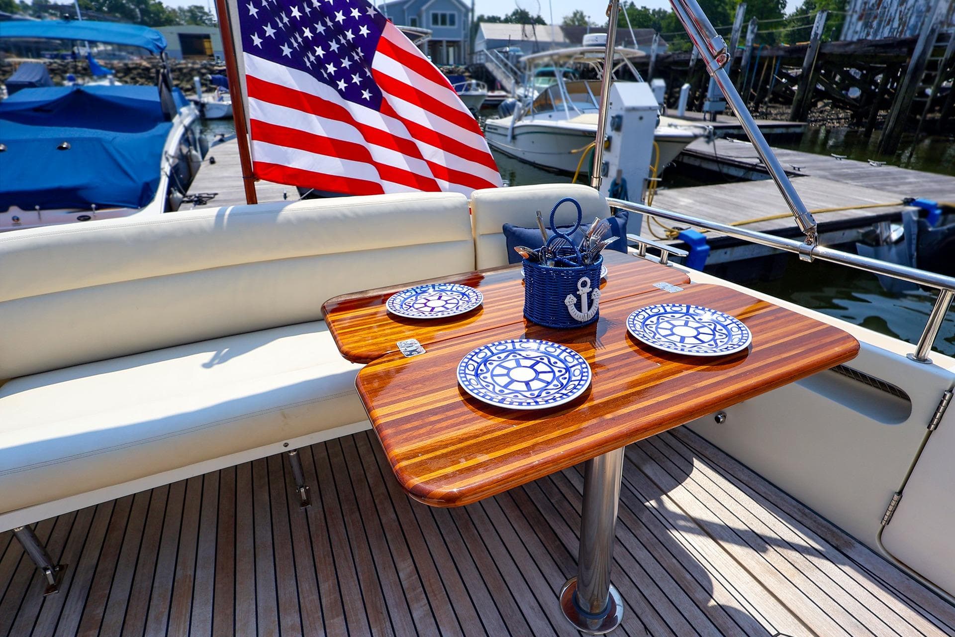 Elegant dining setup on 2010 MJM 40z Downeast yacht with nautical-themed plates and American flag.