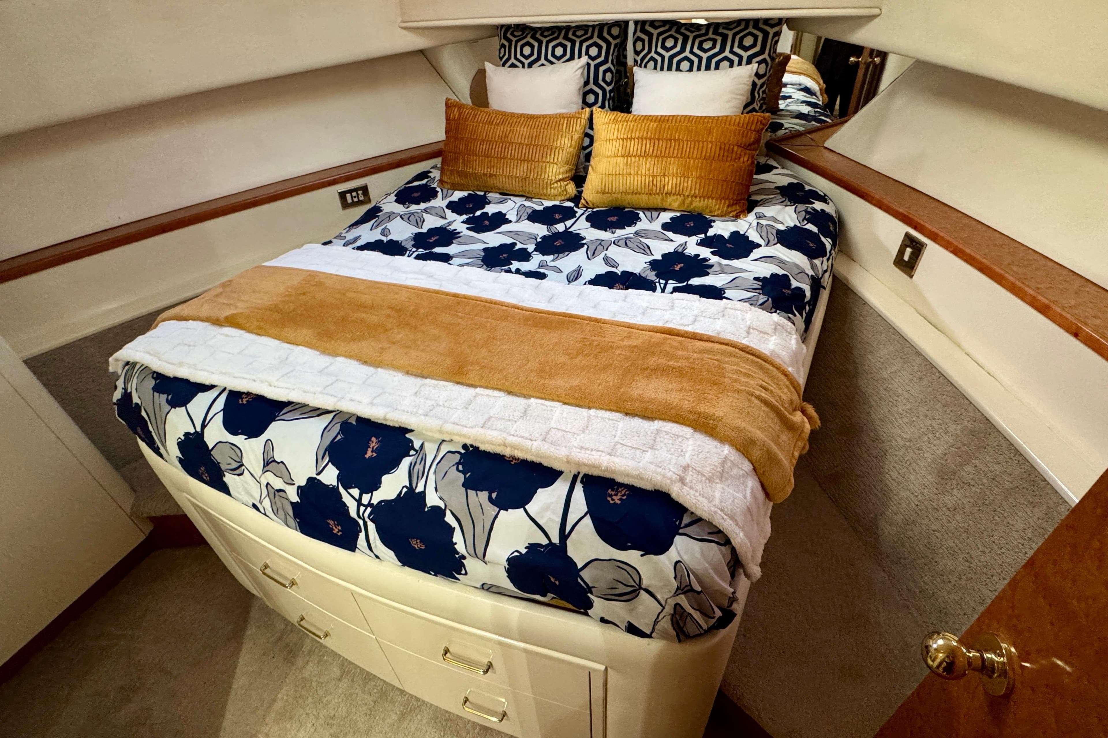 Luxurious bedroom in 1995 Queenship 62 Pilothouse Motor Yacht with floral bedding.
