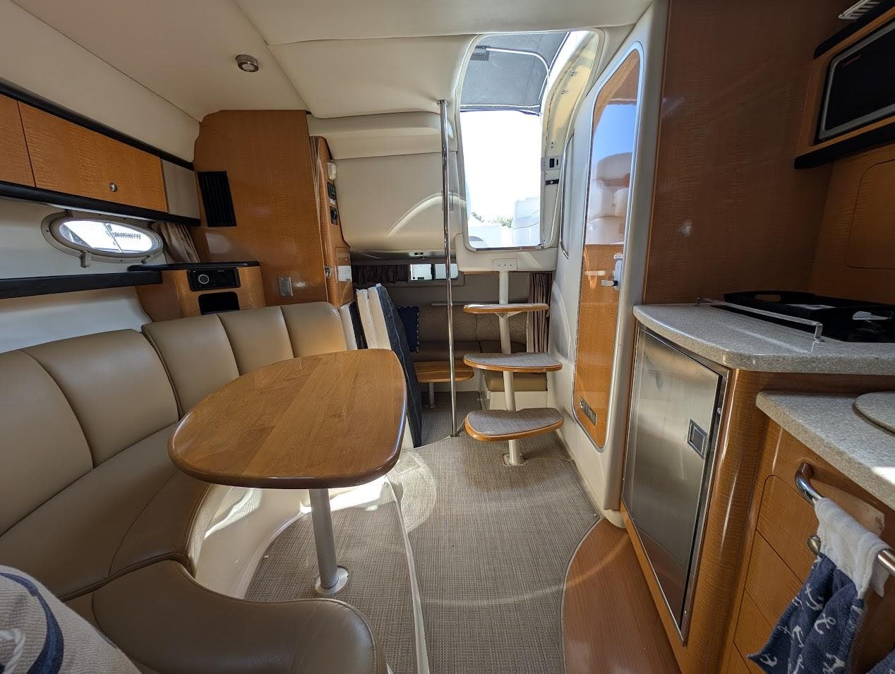 2006 Chaparral 310 Signature yacht interior with dining area, kitchenette, and stairs.