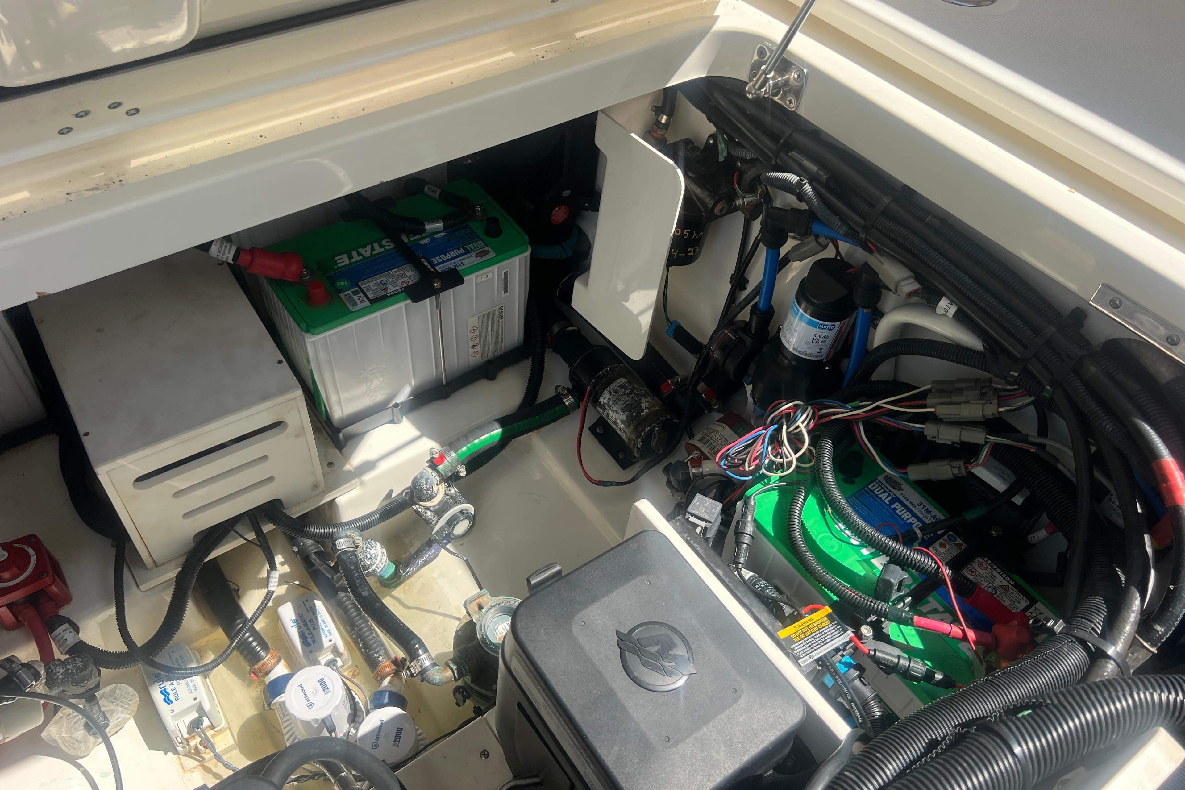 Engine compartment of a 2015 Boston Whaler 320 Vantage with visible wiring and battery.