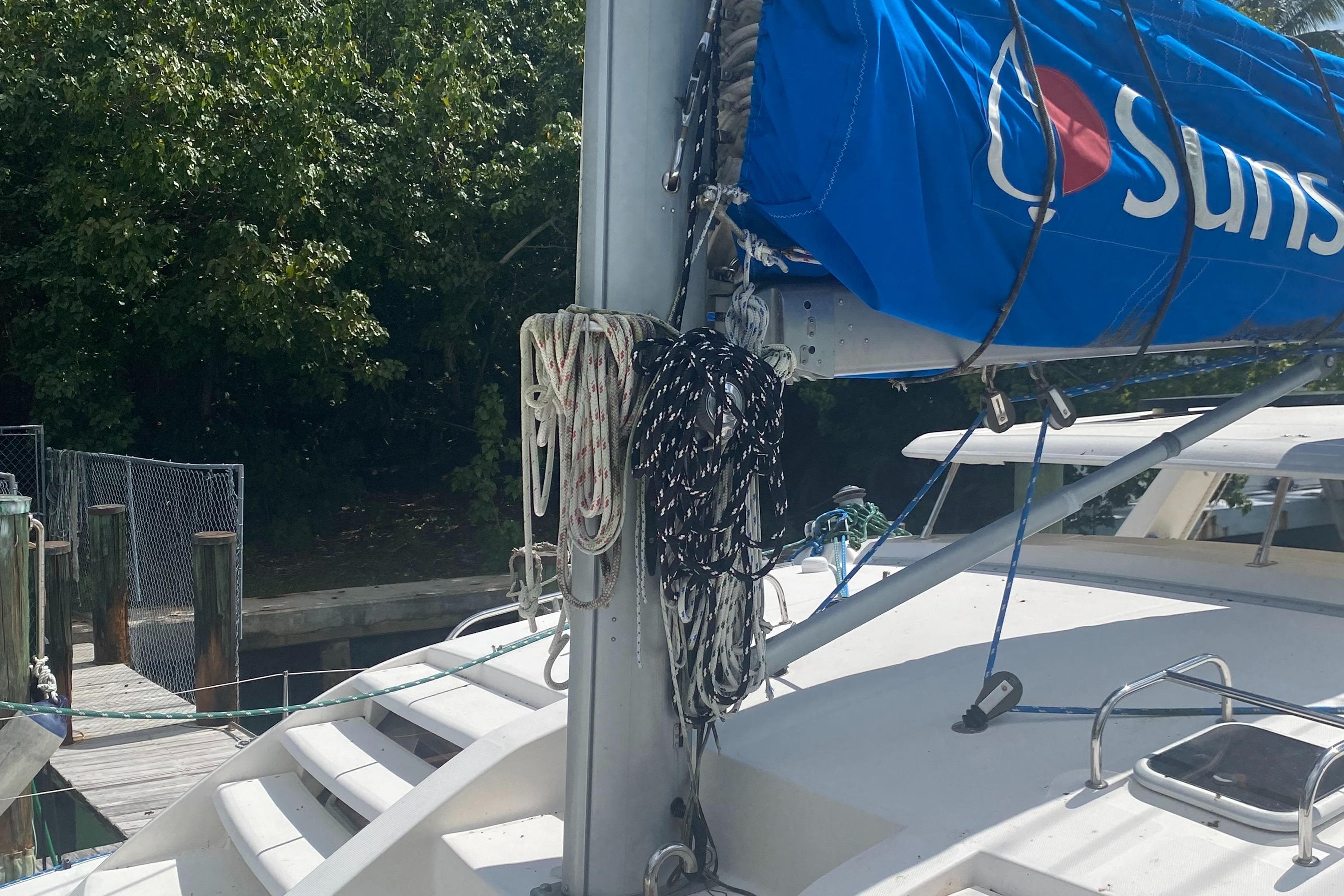 Leopard 38 sailboat, 2003 model, docked with ropes and blue sail cover.