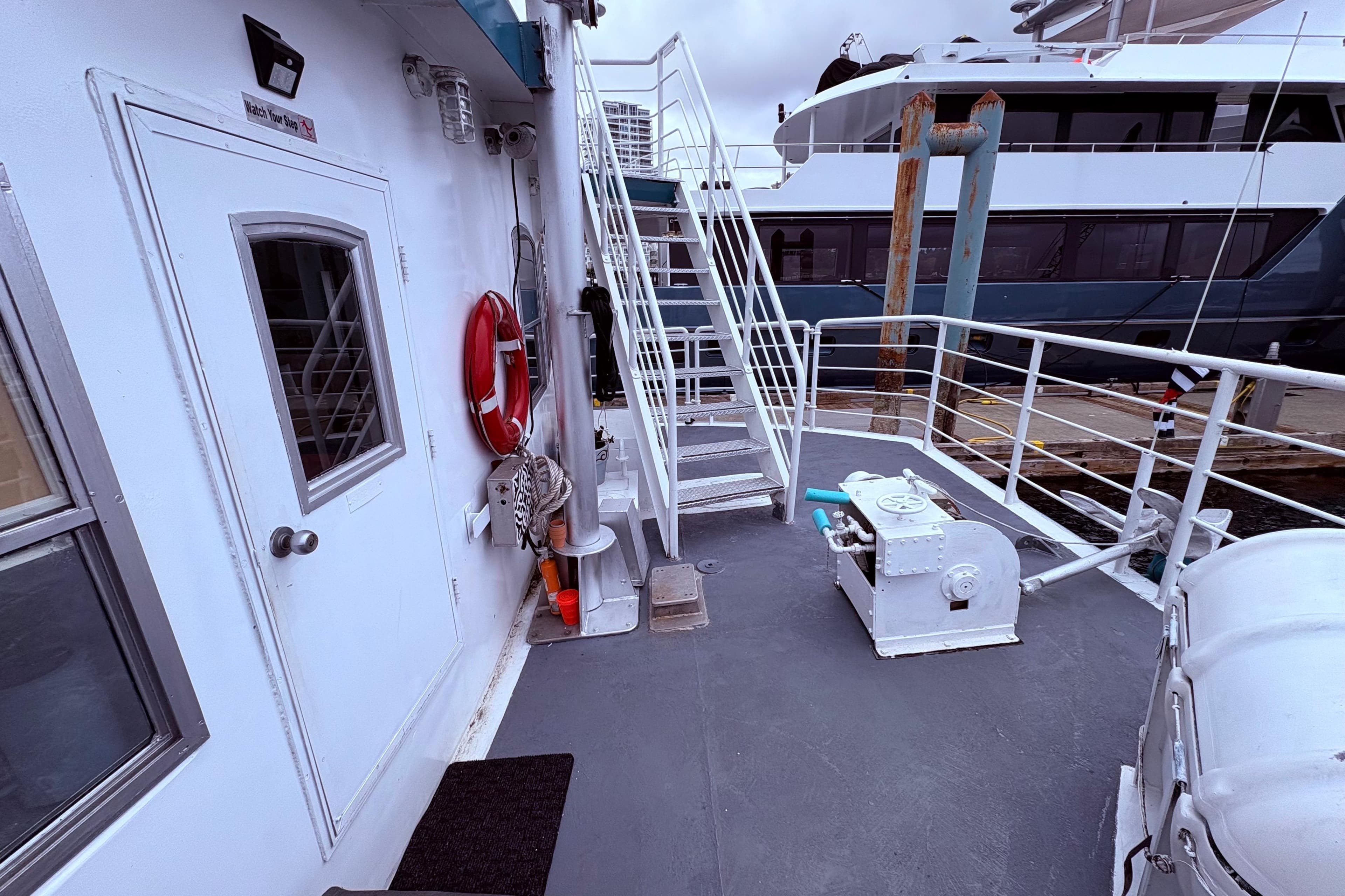 1988 Western Aluminum Craft houseboat conversion with deck, stairs, and safety equipment.
